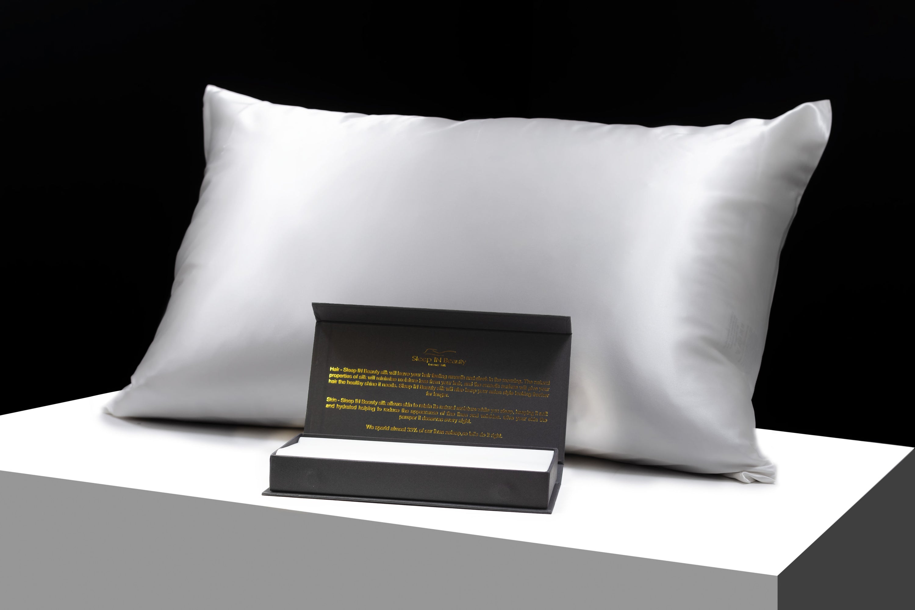 A pair of luxurious SIB™ silk pillowcases in elegant black and gold gift boxes, showcasing their soft texture and hidden zipper design.