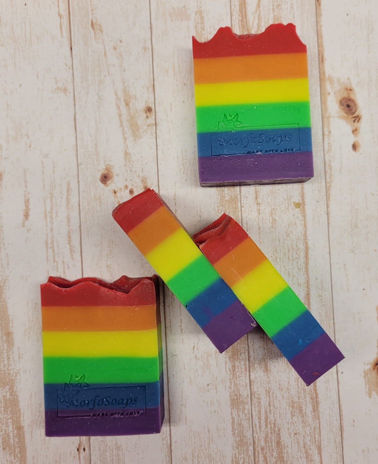 A vibrant bar of Rainbow Soap by Morfosoaps showcasing colorful layers and a fresh scent, handcrafted with natural oils.