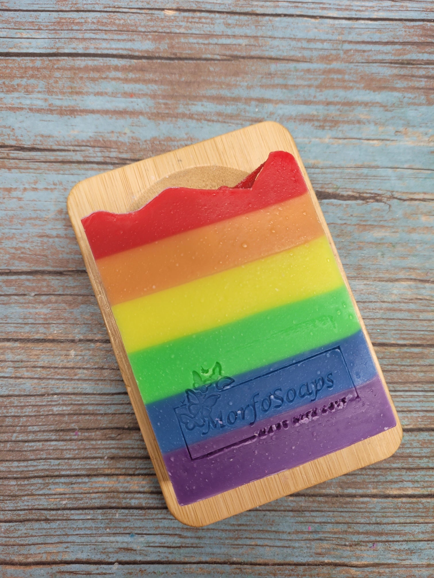 A vibrant bar of Rainbow Soap by Morfosoaps showcasing colorful layers and a fresh scent, handcrafted with natural oils.