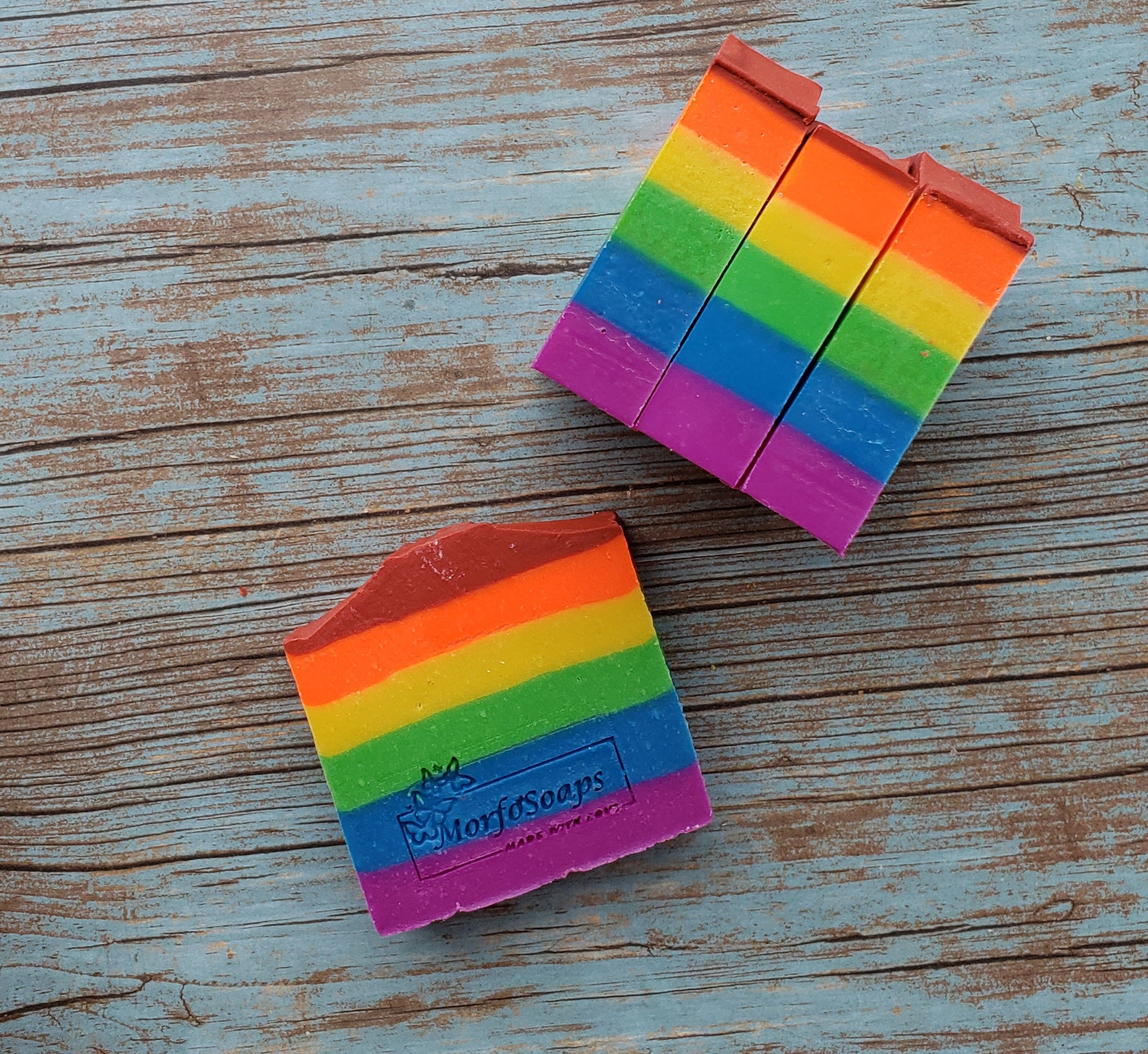 A vibrant bar of Rainbow Soap by Morfosoaps showcasing colorful layers and a fresh scent, handcrafted with natural oils.