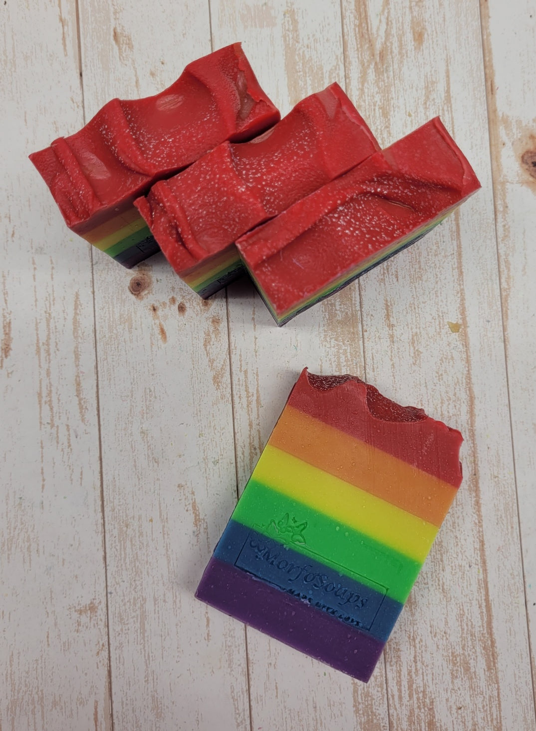 A vibrant bar of Rainbow Soap by Morfosoaps showcasing colorful layers and a fresh scent, handcrafted with natural oils.