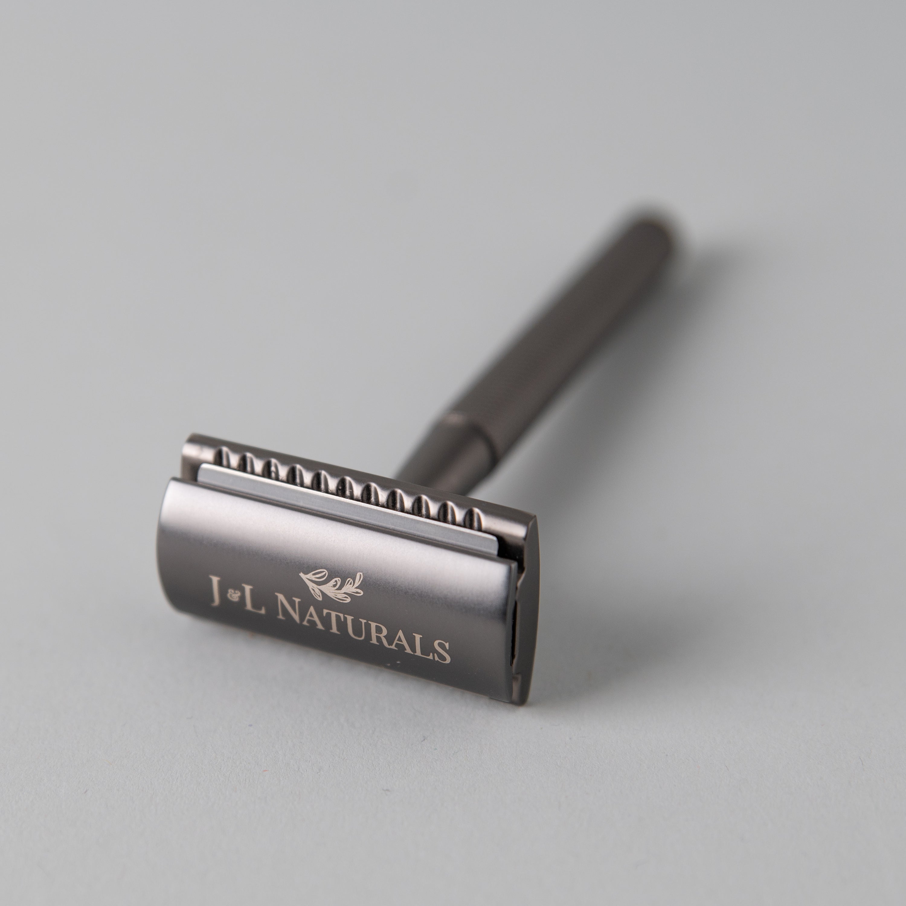 A sleek stainless steel razor set including a double-sided razor and a stylish stand, available in four colors: Black, Rose Gold, Green, and White.