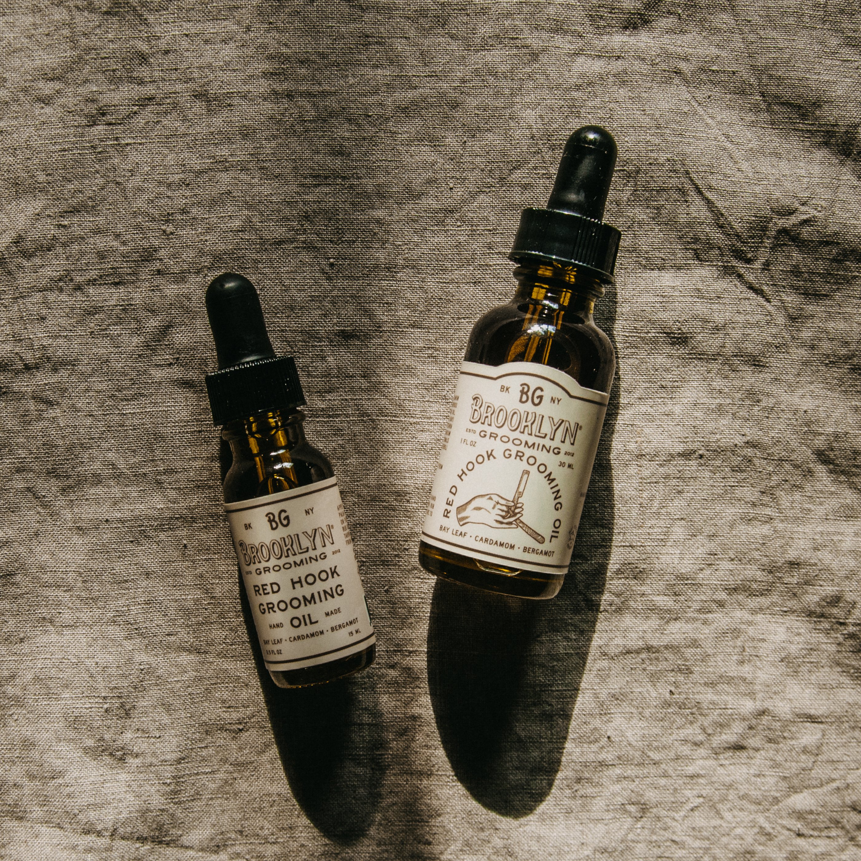 Red Hook Grooming Oil bottle with a sleek design, showcasing its unisex appeal and natural ingredients, perfect for beard, face, and shaving care.