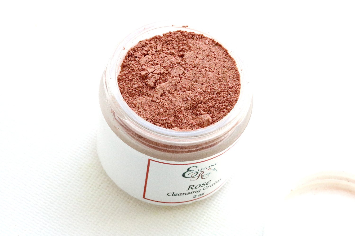 A 2-ounce glass jar of Rose Clay Mask powder, showcasing its natural ingredients and gentle exfoliating properties for dry and normal skin.