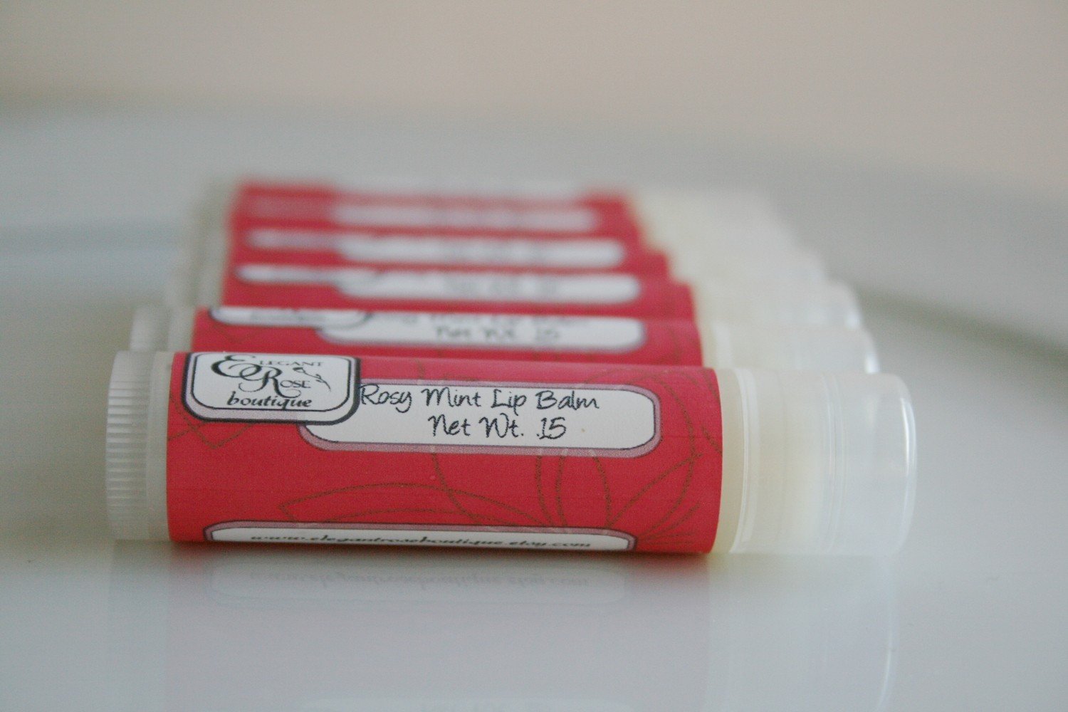 A tube of Rose Mint Lip Balm featuring a floral design, showcasing its luxurious rose and peppermint scent.