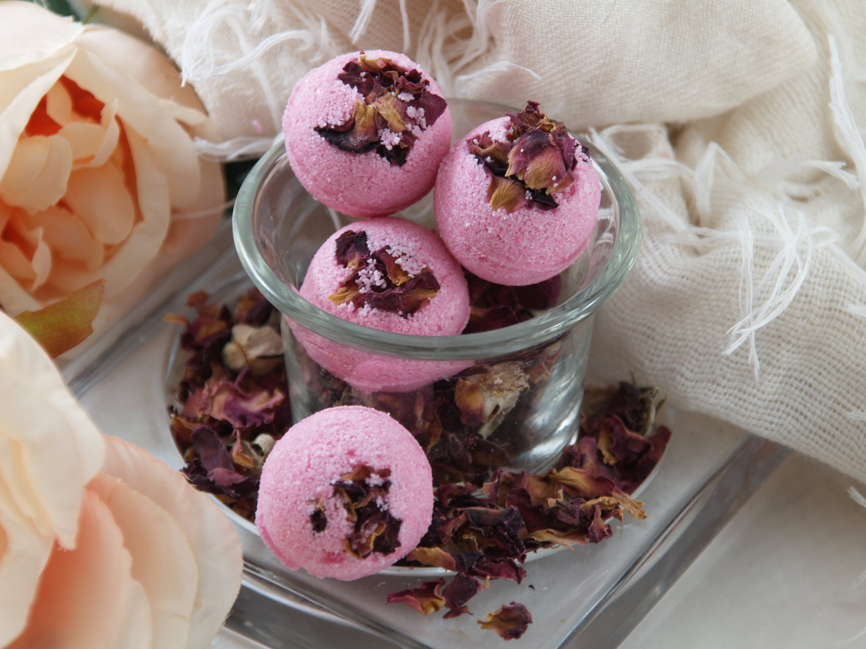 A vibrant Rose Petal Bath Bomb with rose petals, showcasing its colorful and luxurious design, perfect for a relaxing bath experience.