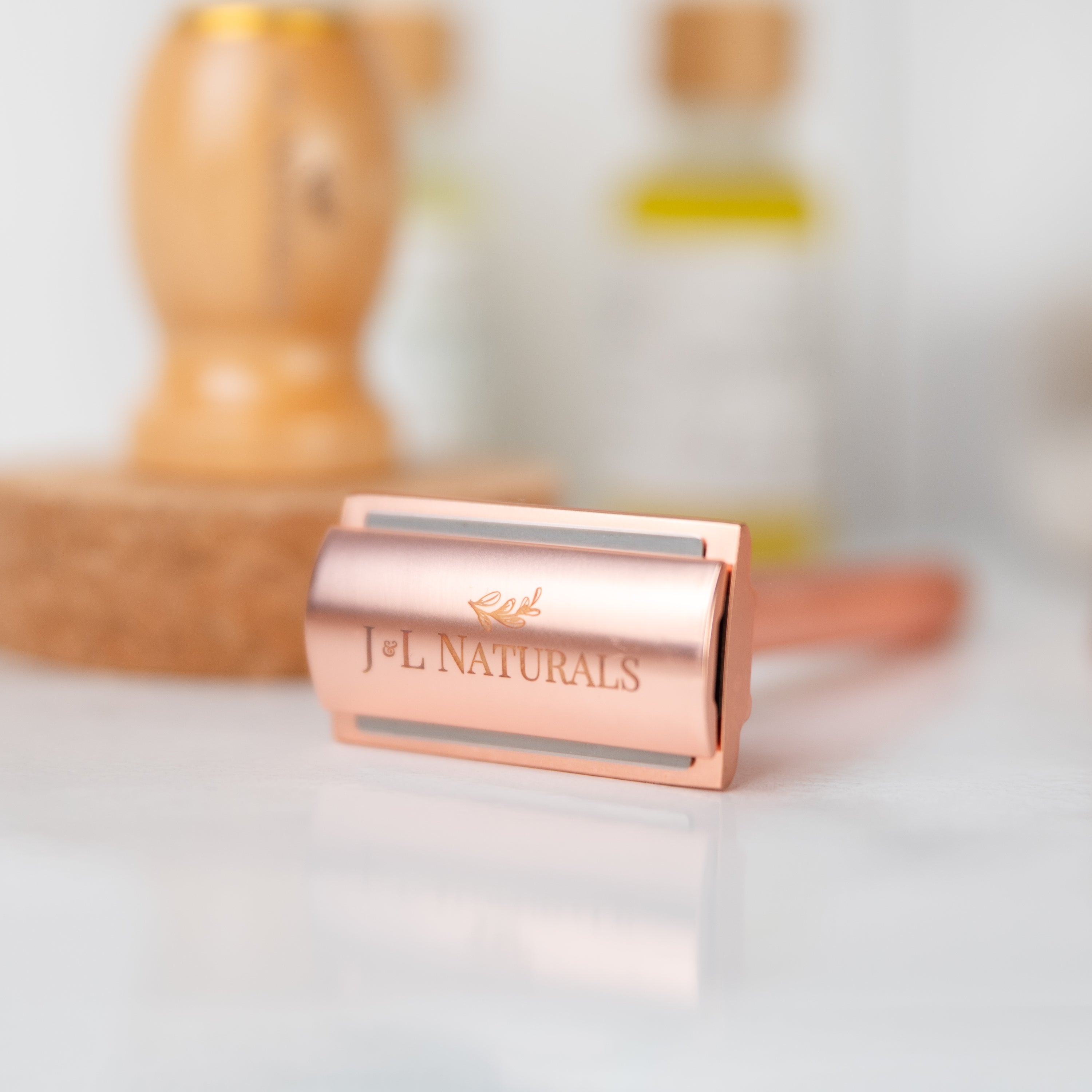 A sleek stainless steel safety razor with five refill blades, available in Black, Rose Gold, Green, and White, showcasing its ergonomic design.