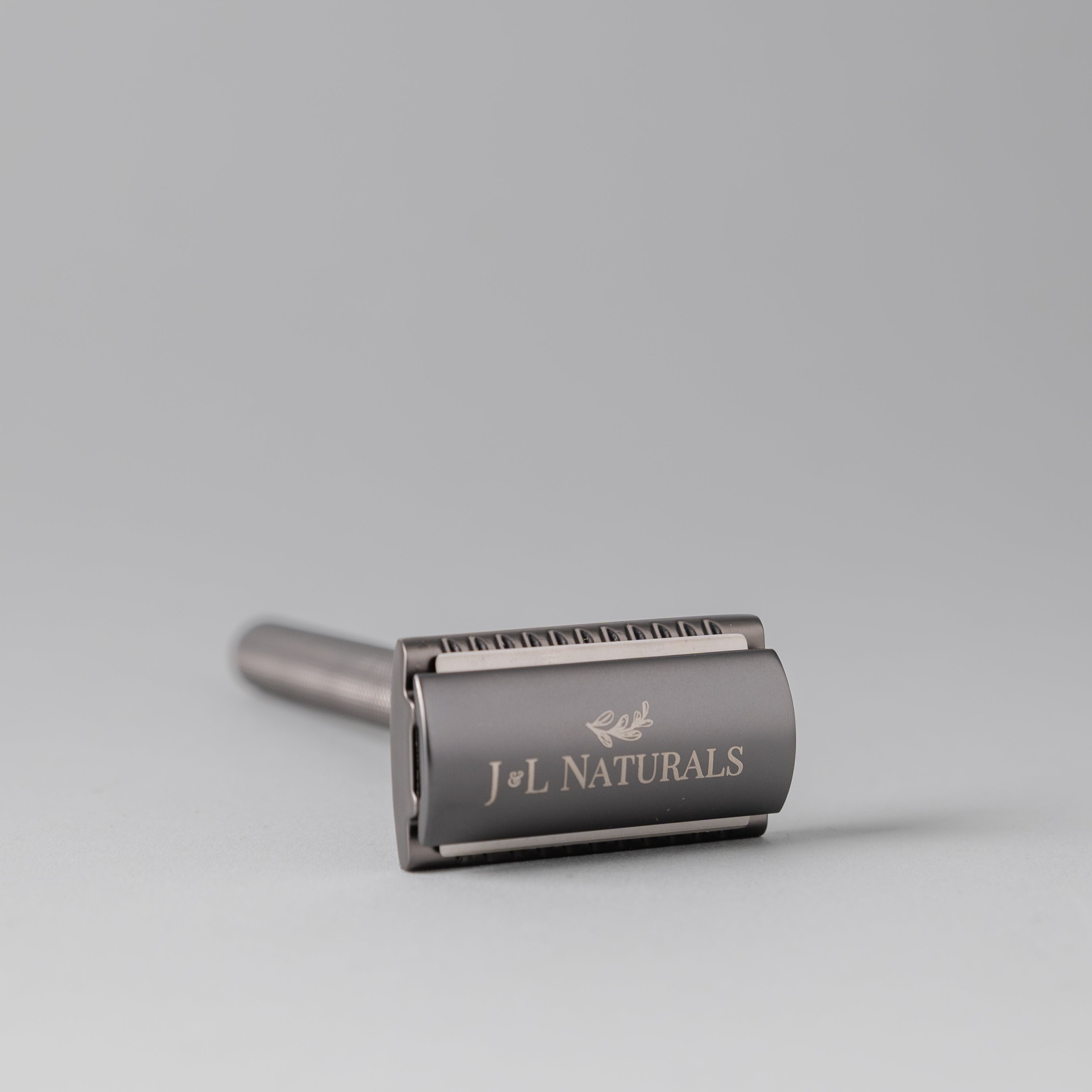 A sleek stainless steel safety razor with five refill blades, available in Black, Rose Gold, Green, and White, showcasing its ergonomic design.