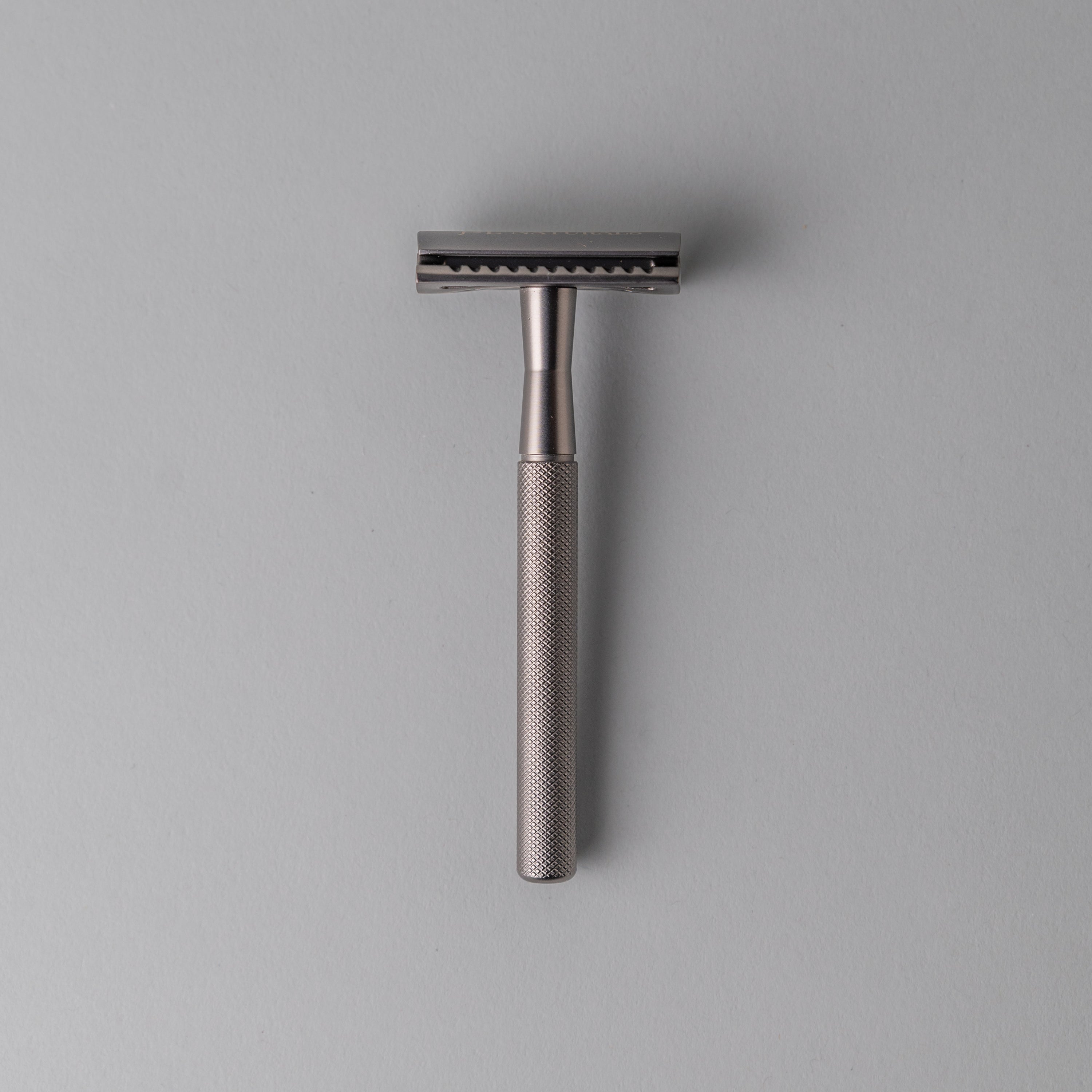 A sleek stainless steel safety razor with five refill blades, available in Black, Rose Gold, Green, and White, showcasing its ergonomic design.