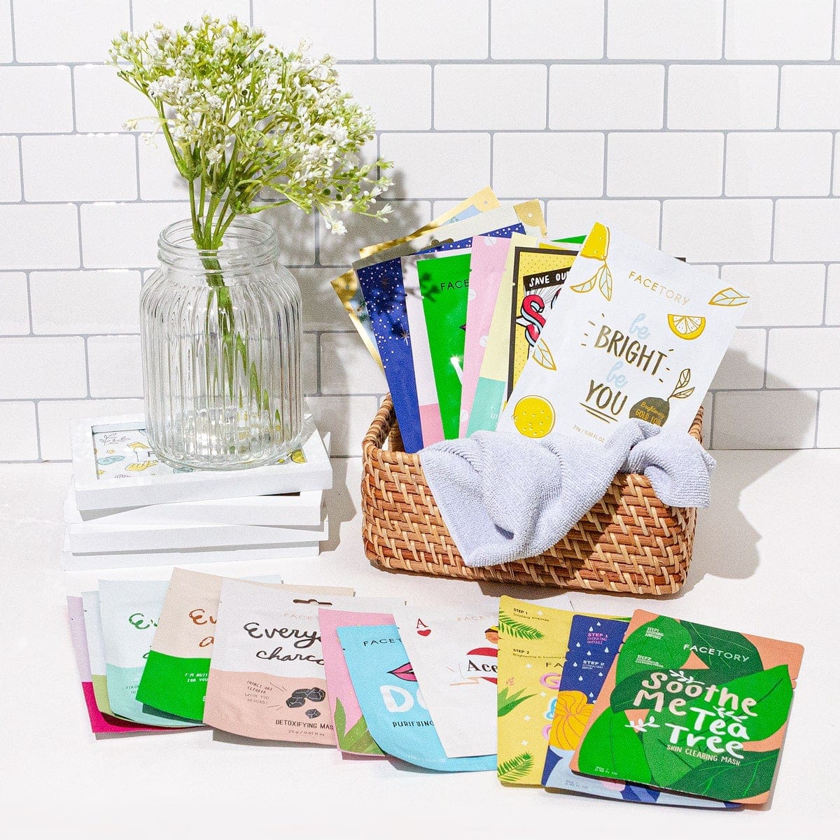 A collection of 23 colorful facial sheet masks and a stylish spa hairband, perfect for skincare enthusiasts.