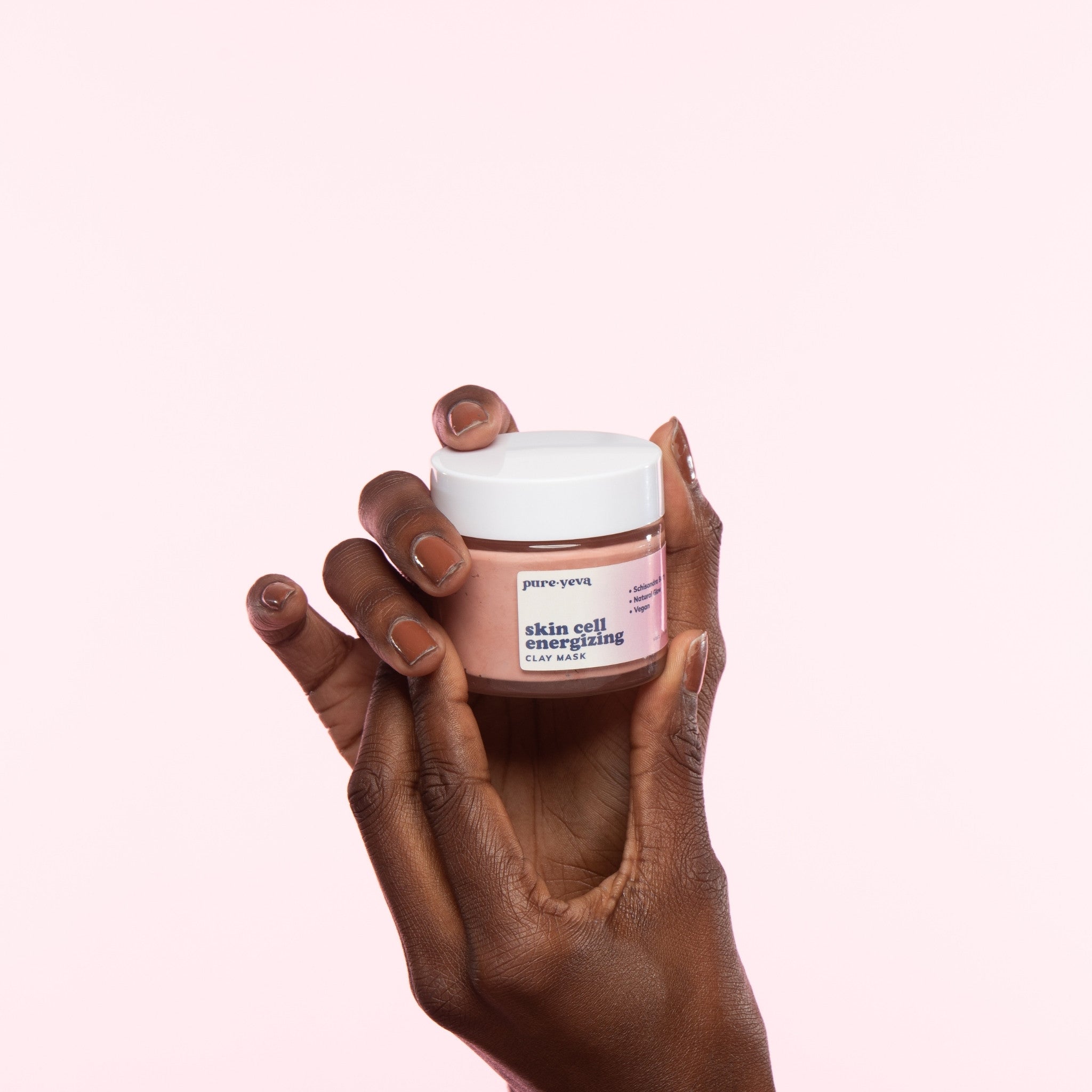 Skin Cell Energizing Clay Mask in a jar with natural ingredients surrounding it, showcasing its rejuvenating properties.