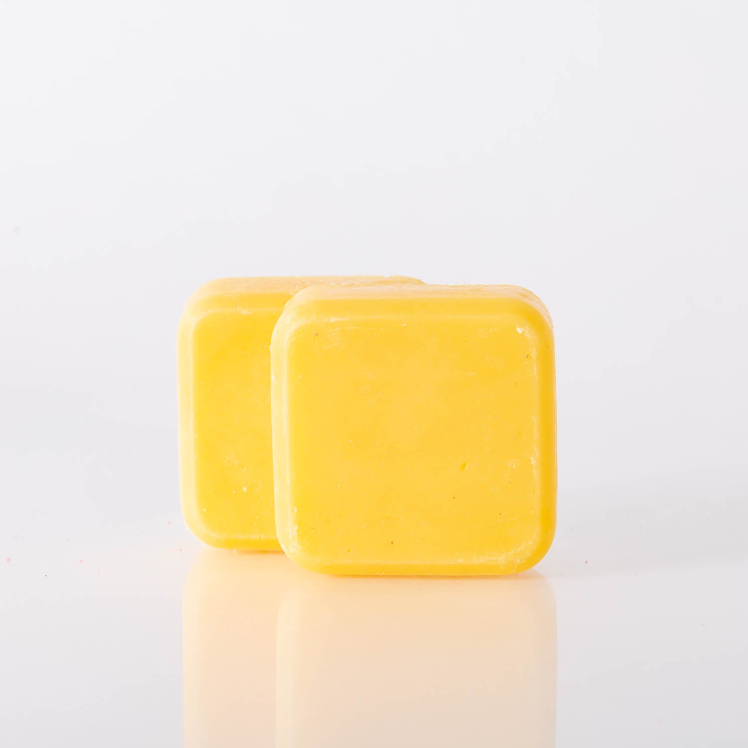 Sunshine Face & Body Soap bar with orange oil and zest, showcasing its vibrant color and texture, perfect for hydrating skin.