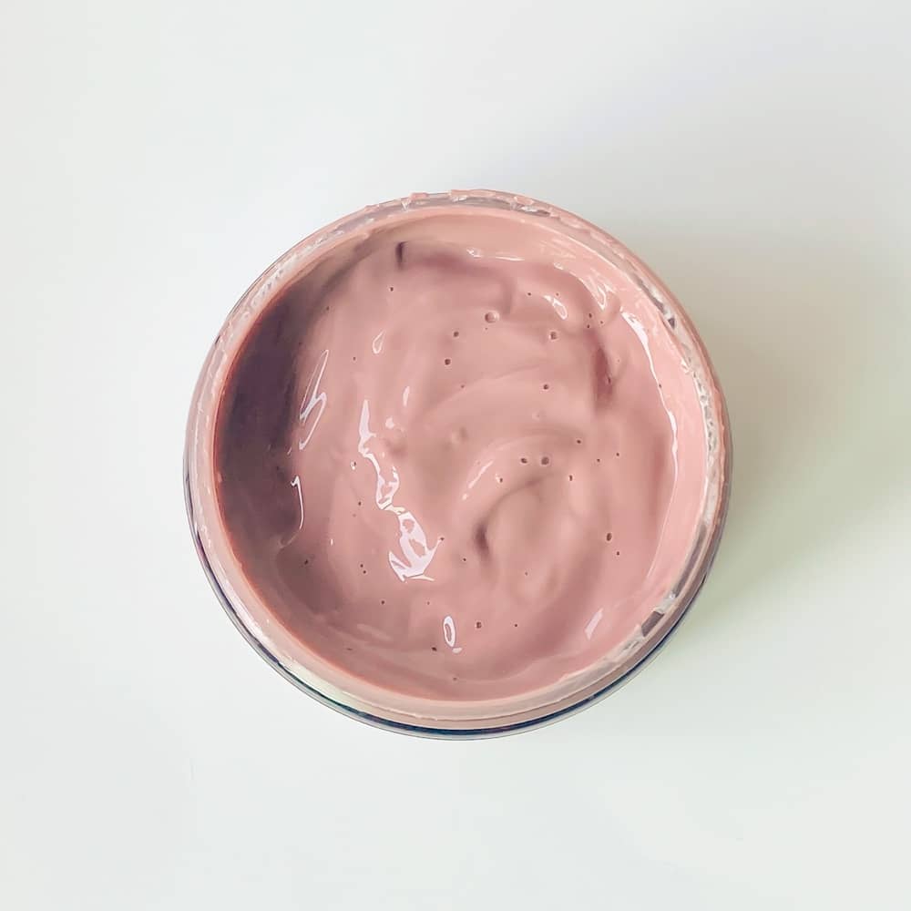 Sunshiny CLAY Mask in a jar with a clay gel texture, surrounded by natural ingredients like spinach and licorice root.