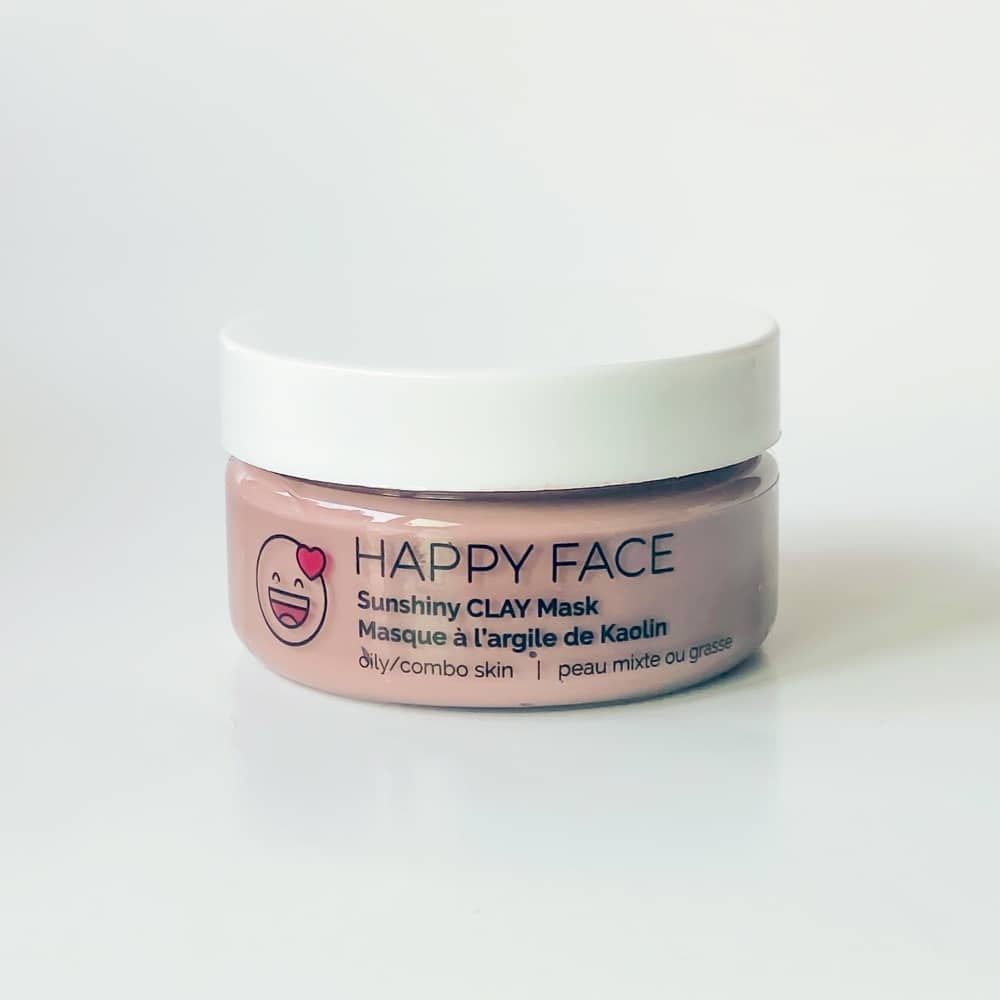 Sunshiny CLAY Mask in a jar with a clay gel texture, surrounded by natural ingredients like spinach and licorice root.