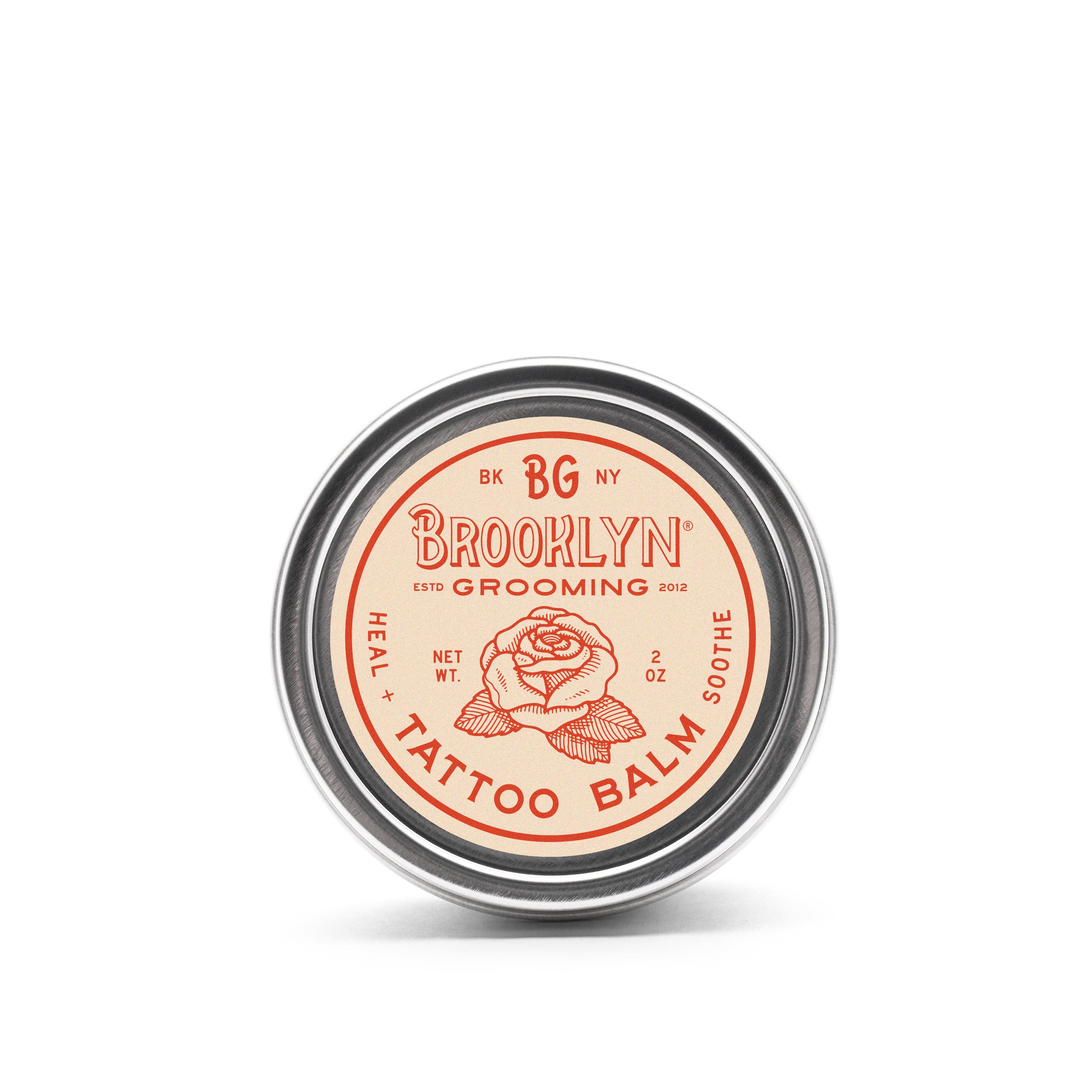 A 2 oz. jar of Tattoo Balm featuring natural ingredients for tattoo aftercare, with a soothing texture and organic label.