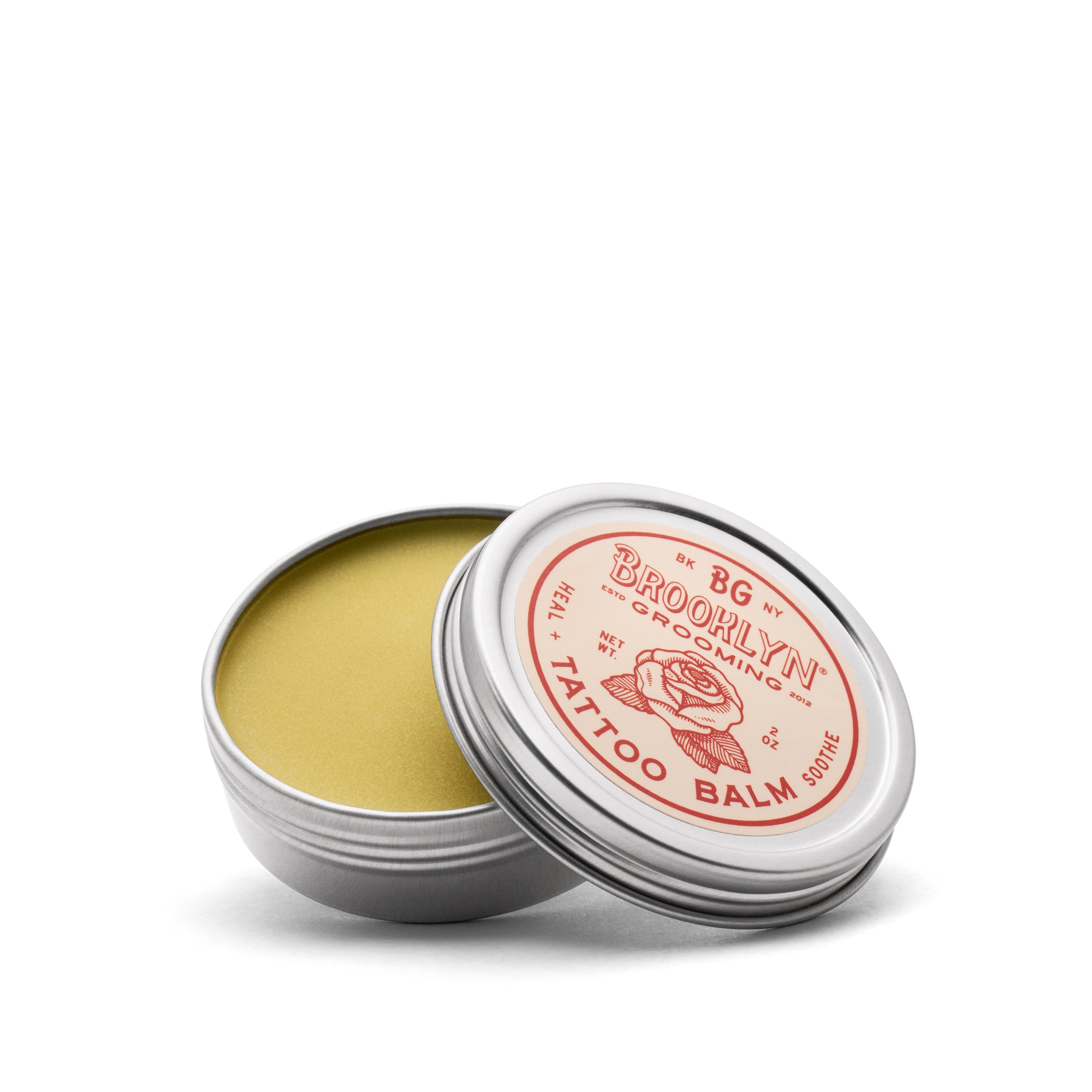 A 2 oz. jar of Tattoo Balm featuring natural ingredients for tattoo aftercare, with a soothing texture and organic label.