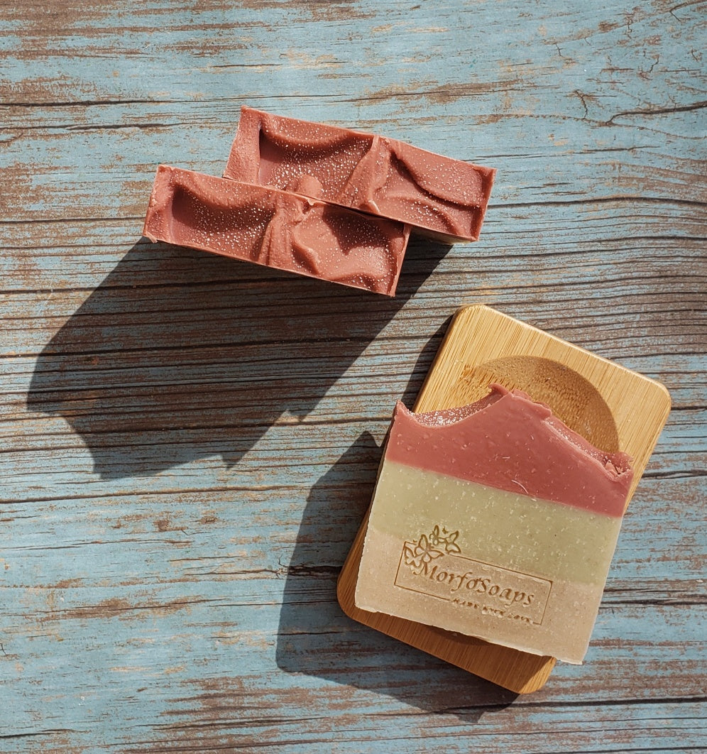 Handmade Triple Clay Soap bar with Sweet Orange essential oil, showcasing its unique colors and textures.