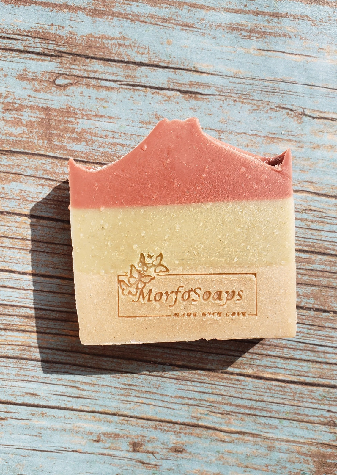 Handmade Triple Clay Soap bar with Sweet Orange essential oil, showcasing its unique colors and textures.