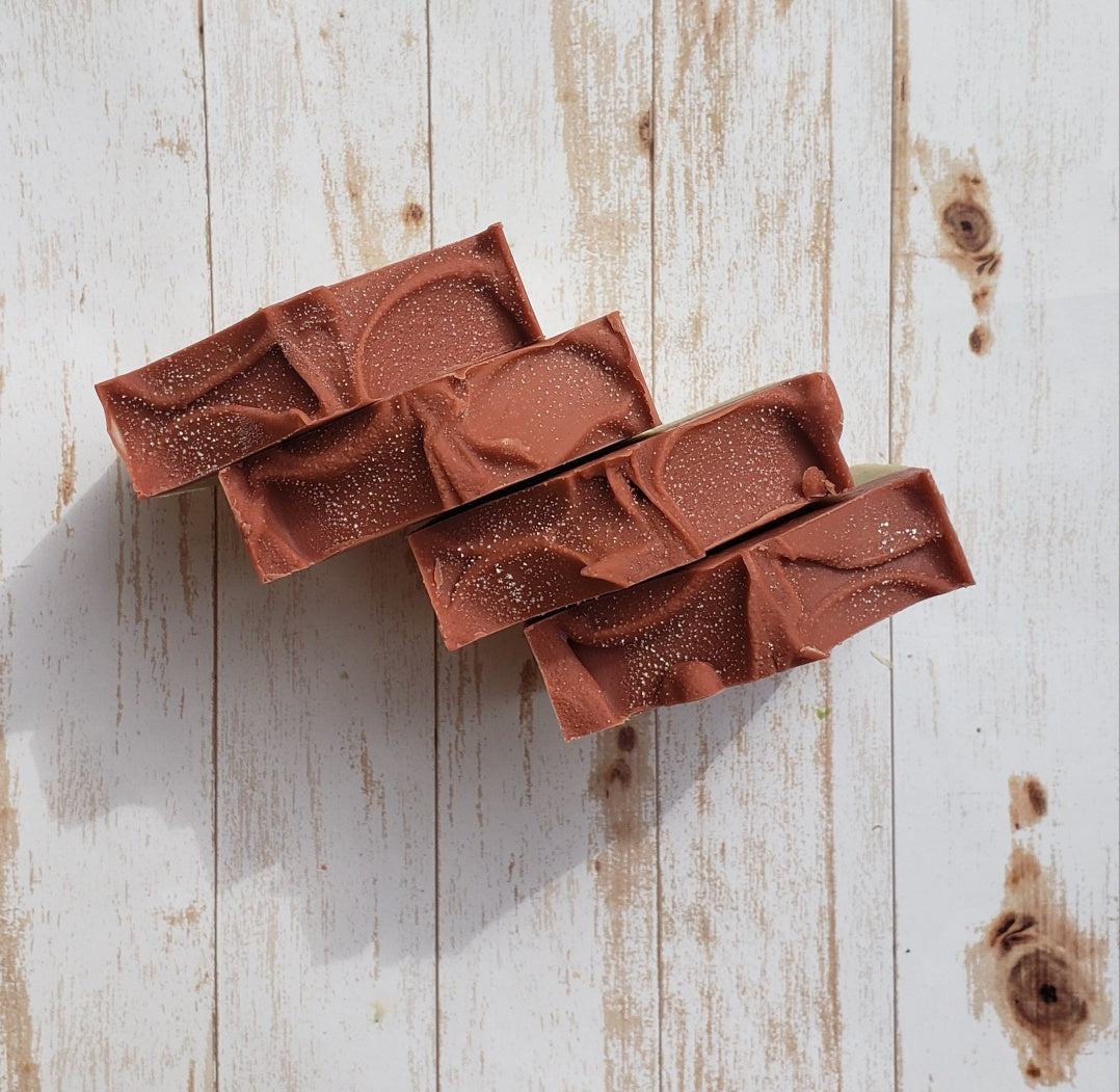 Handmade Triple Clay Soap bar with Sweet Orange essential oil, showcasing its unique colors and textures.