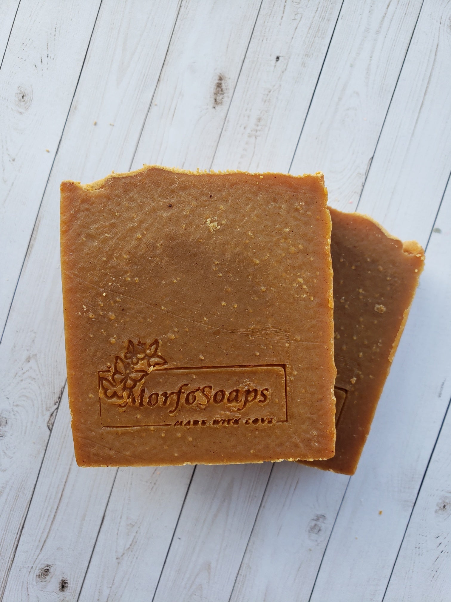 Turmeric Handmade Soap bar with a vibrant yellow color, showcasing its unique texture and natural ingredients, placed on a wooden surface.