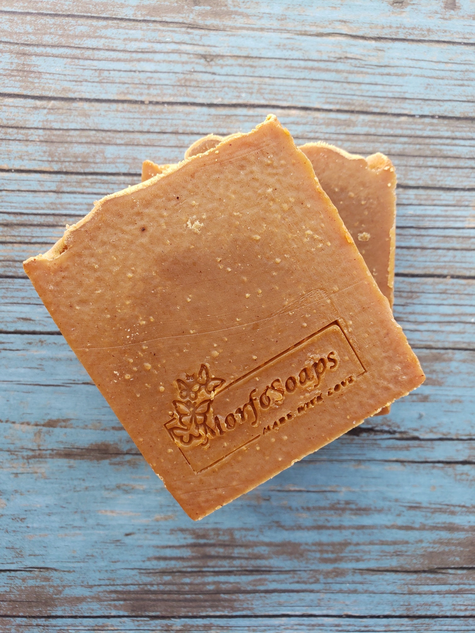 Turmeric Handmade Soap bar with a vibrant yellow color, showcasing its unique texture and natural ingredients, placed on a wooden surface.