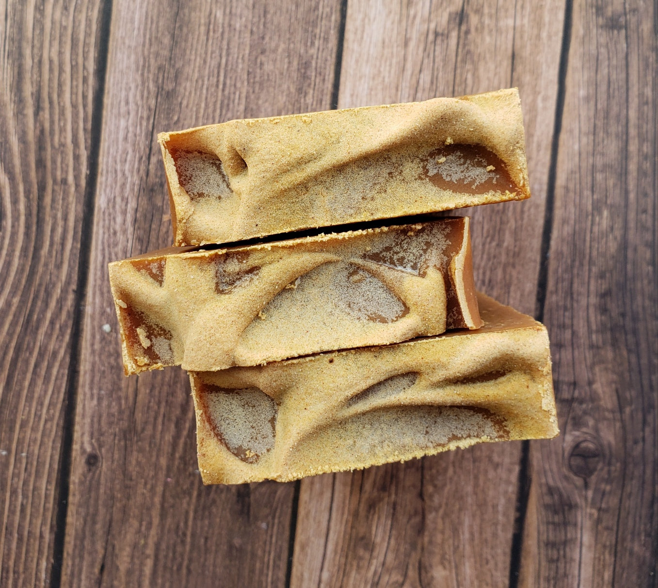 Turmeric Handmade Soap bar with a vibrant yellow color, showcasing its unique texture and natural ingredients, placed on a wooden surface.