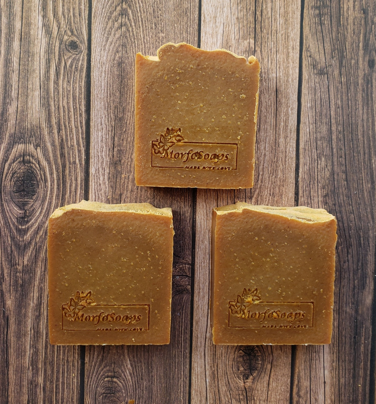 Turmeric Handmade Soap bar with a vibrant yellow color, showcasing its unique texture and natural ingredients, placed on a wooden surface.