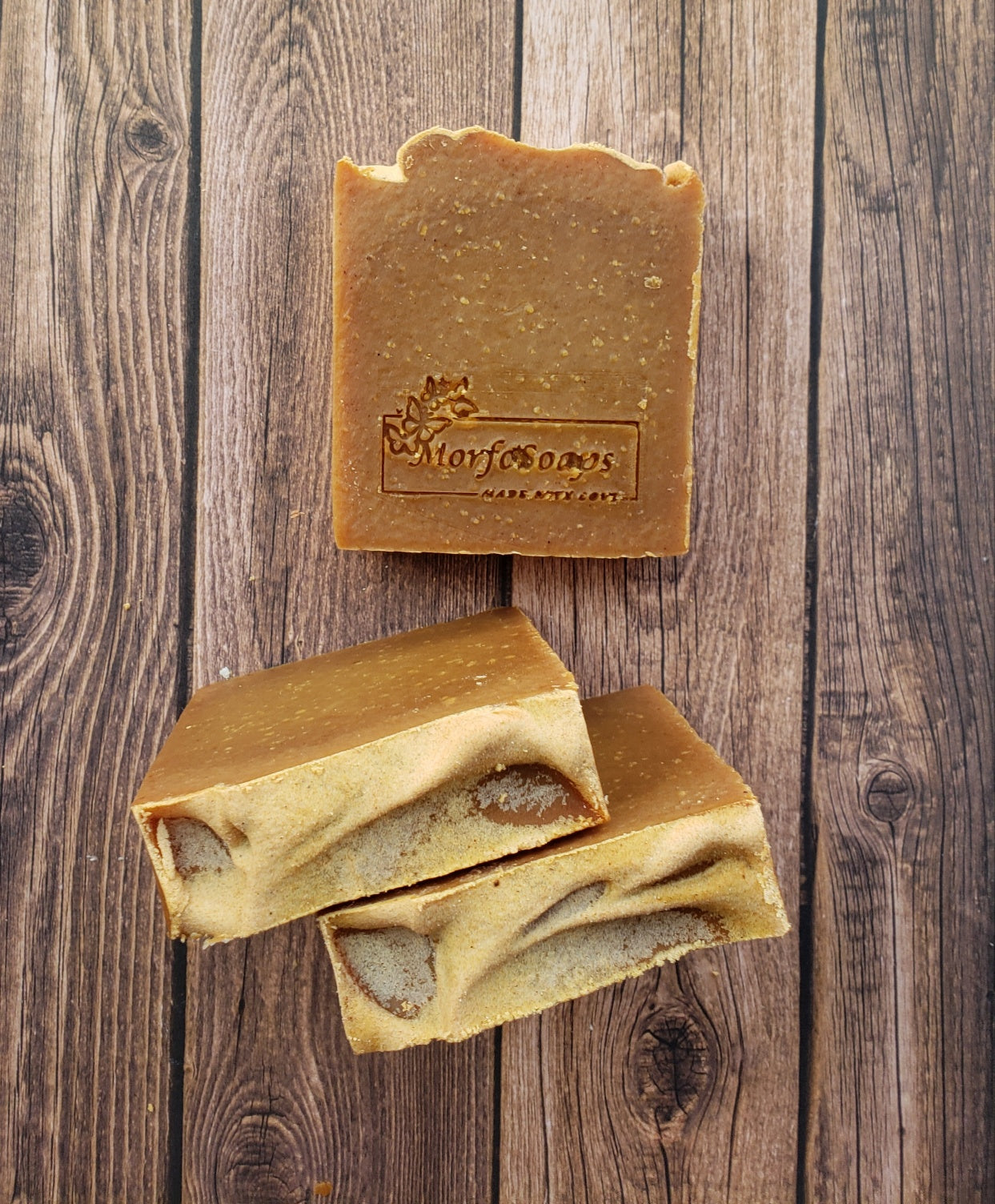 Turmeric Handmade Soap bar with a vibrant yellow color, showcasing its unique texture and natural ingredients, placed on a wooden surface.