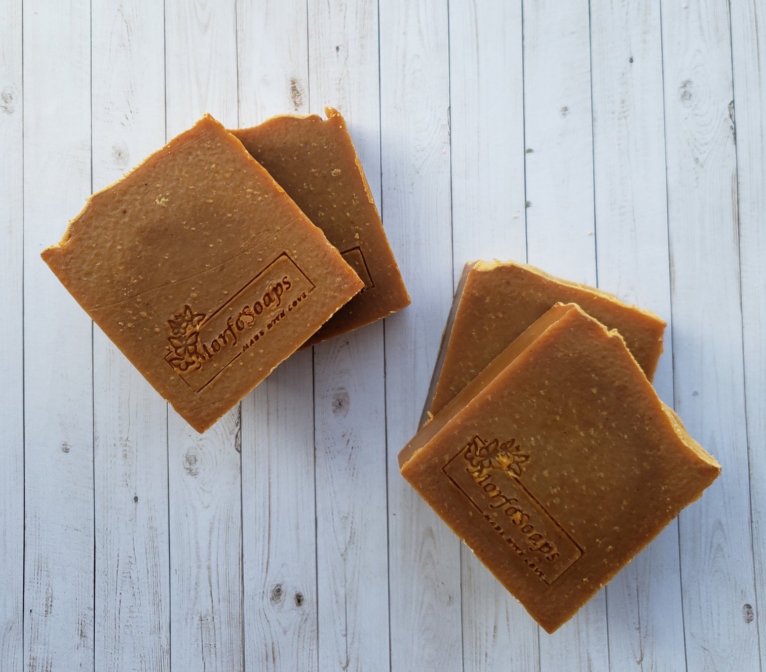 Turmeric Handmade Soap bar with a vibrant yellow color, showcasing its unique texture and natural ingredients, placed on a wooden surface.