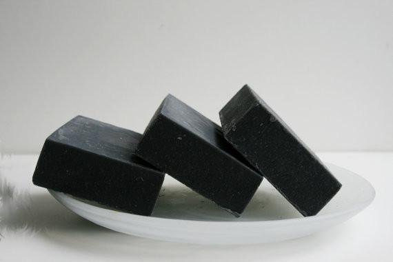 A bar of unscented activated charcoal soap with a smooth texture, showcasing its dark color and natural ingredients.