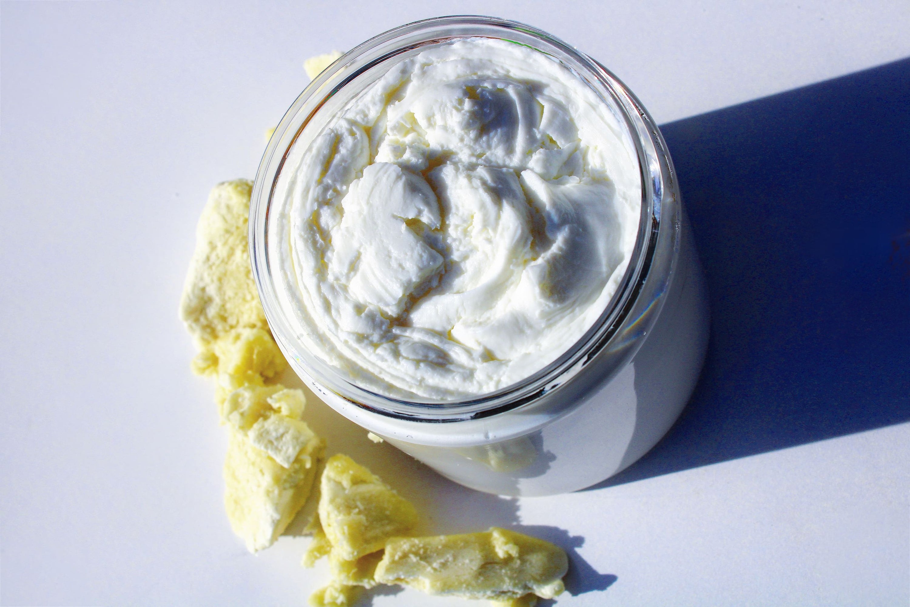 A jar of unscented body buttercream showcasing its creamy texture, ideal for sensitive skin hydration.