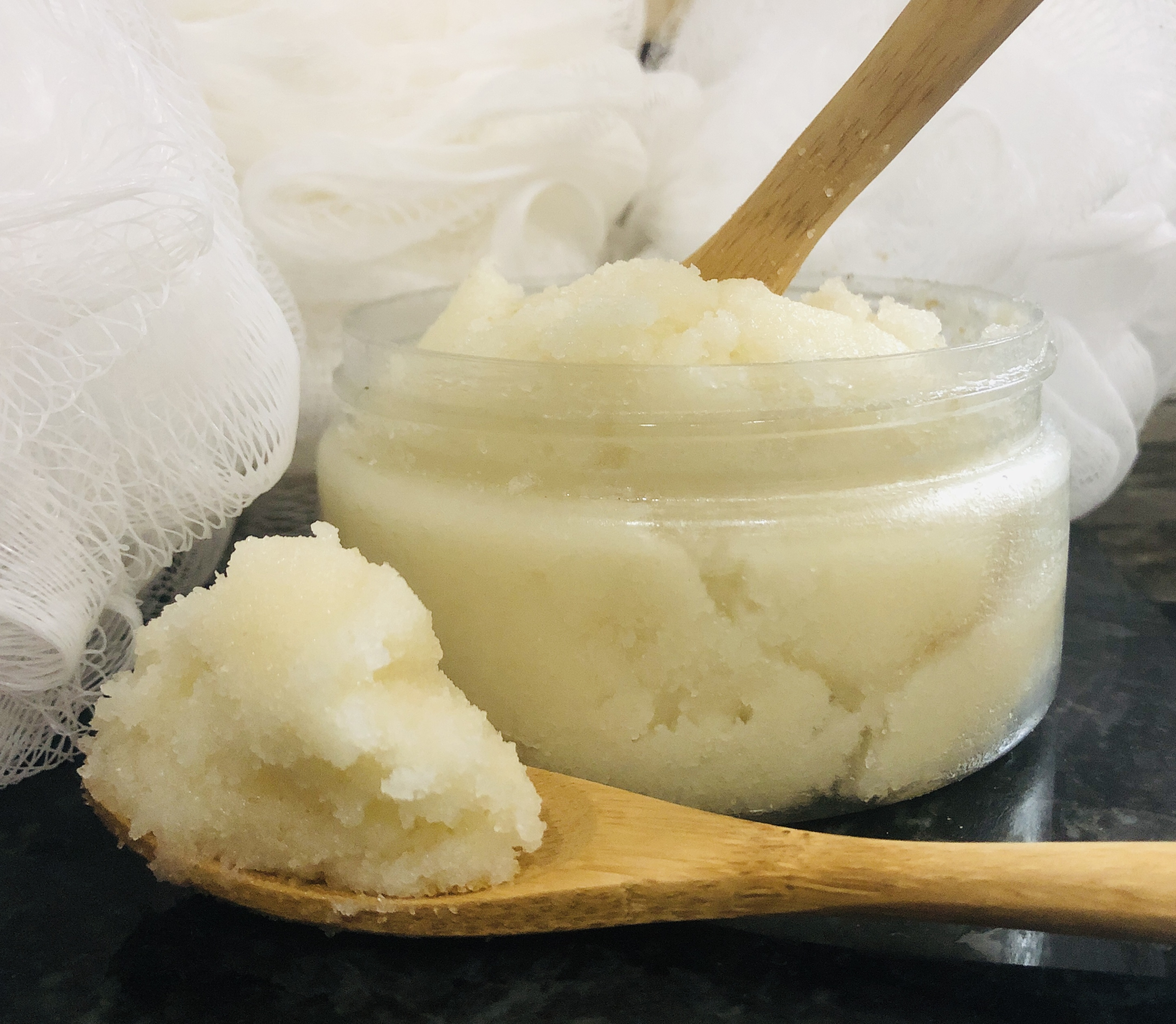 A jar of Whipped Body Sugar Scrub in various scents, showcasing its creamy texture and natural ingredients.