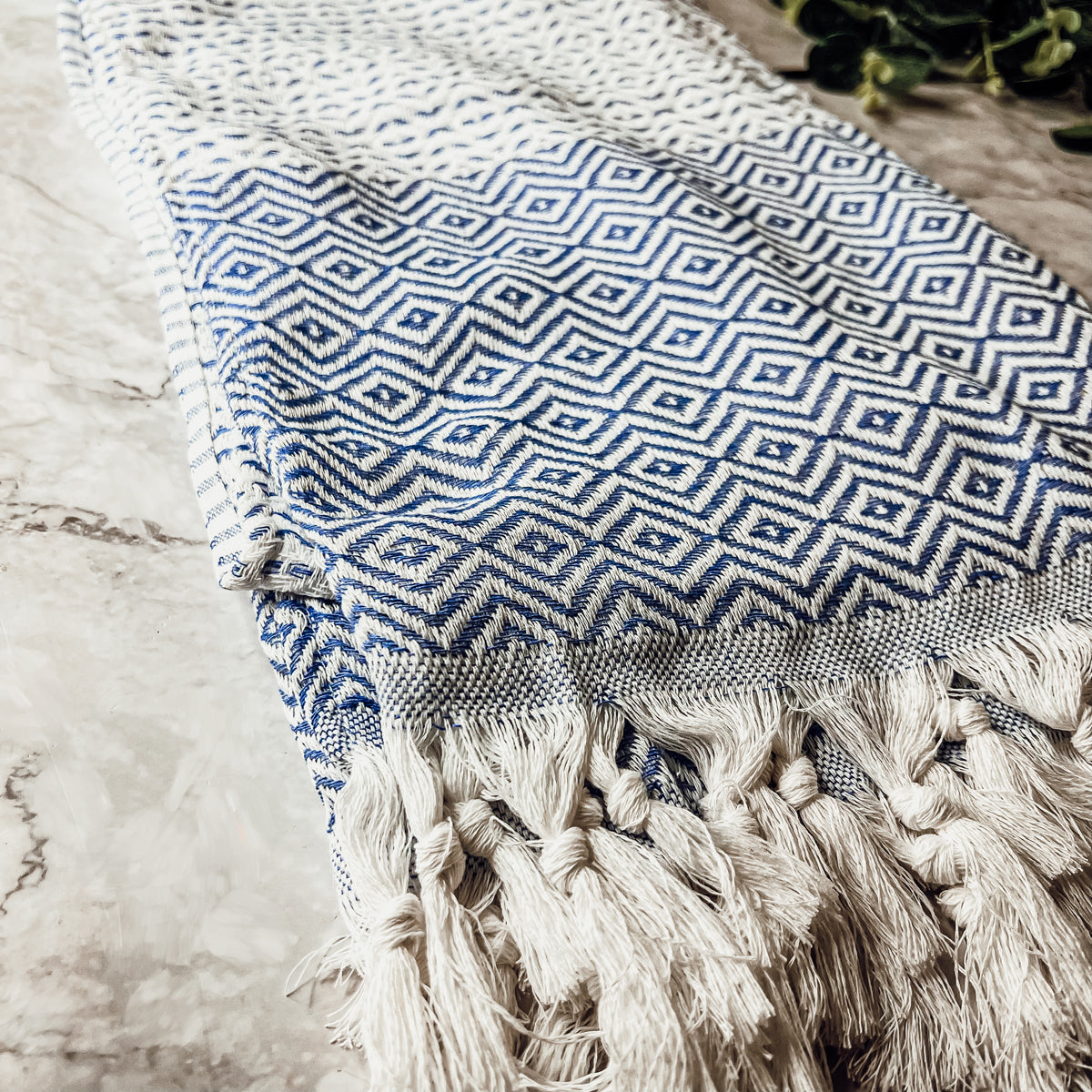 Azra Towel 200GSM in blue and gray with decorative tassels, showcasing its oversized design and soft texture.