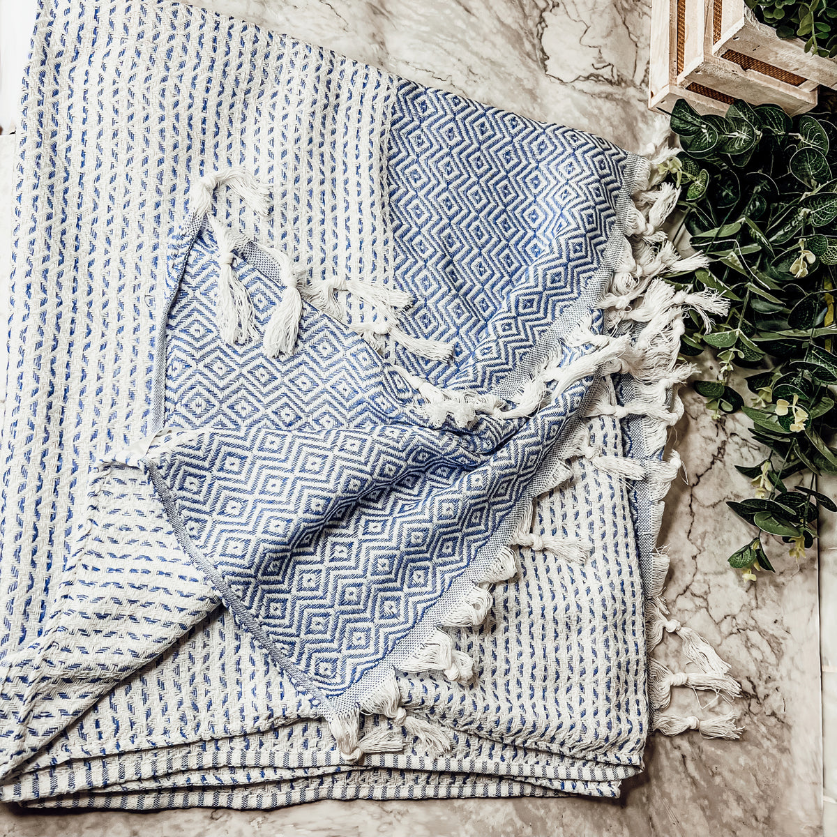 Azra Towel 200GSM in blue and gray with decorative tassels, showcasing its oversized design and soft texture.