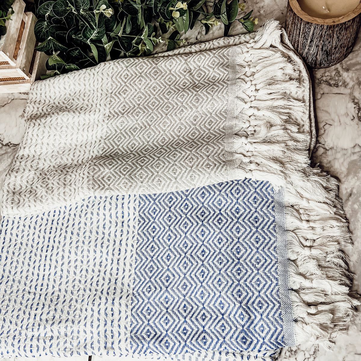 Azra Towel 200GSM in blue and gray with decorative tassels, showcasing its oversized design and soft texture.