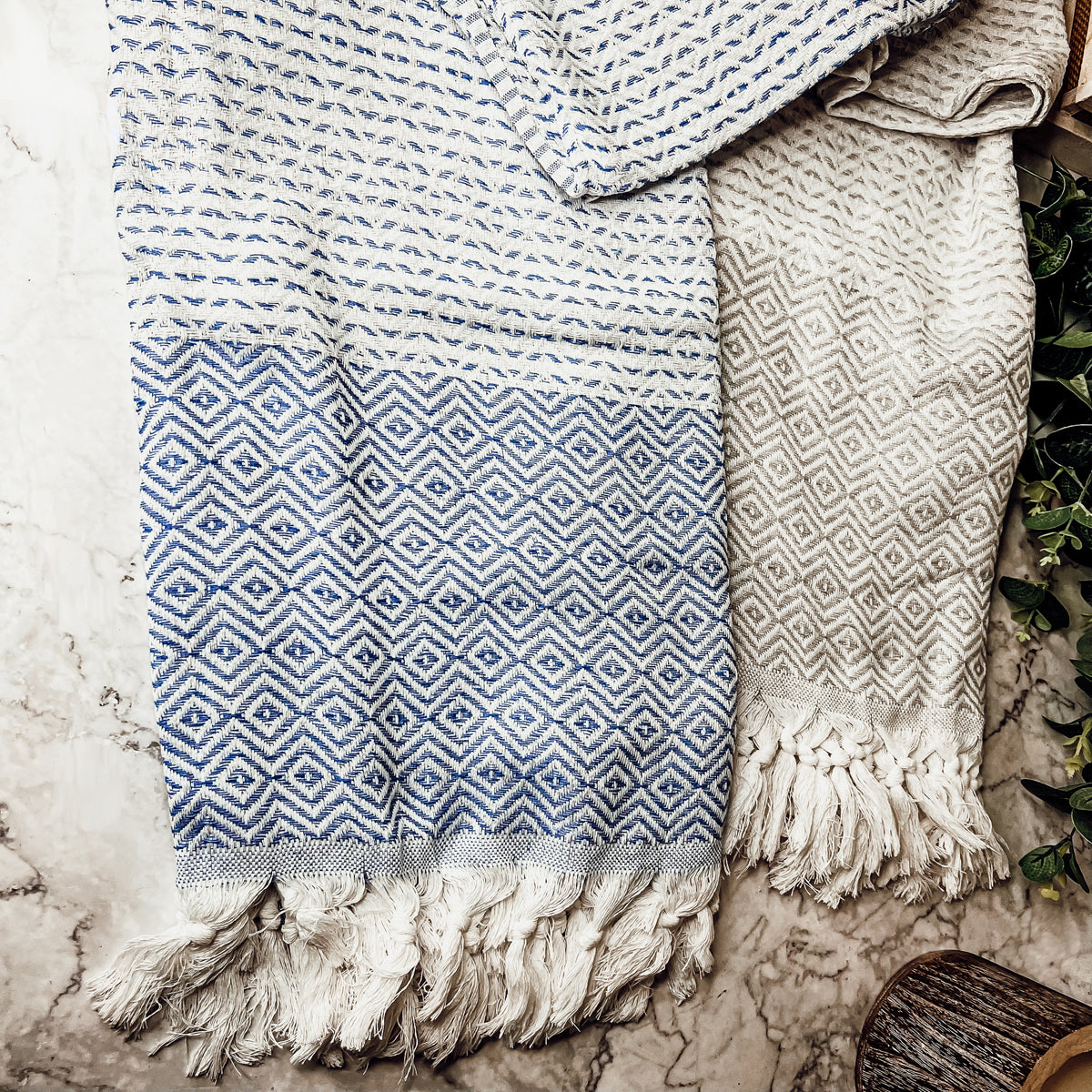 Azra Towel 200GSM in blue and gray with decorative tassels, showcasing its oversized design and soft texture.