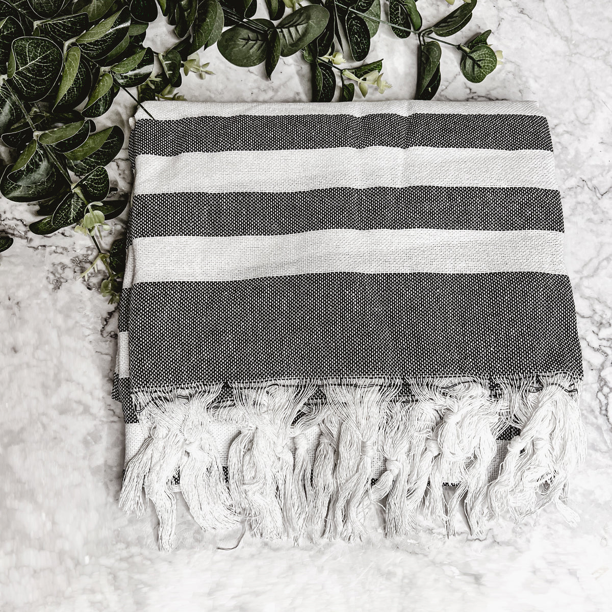 Bold Towel 180GSM made from 100% Turkish cotton, featuring decorative tassels and striped design in charcoal or green.