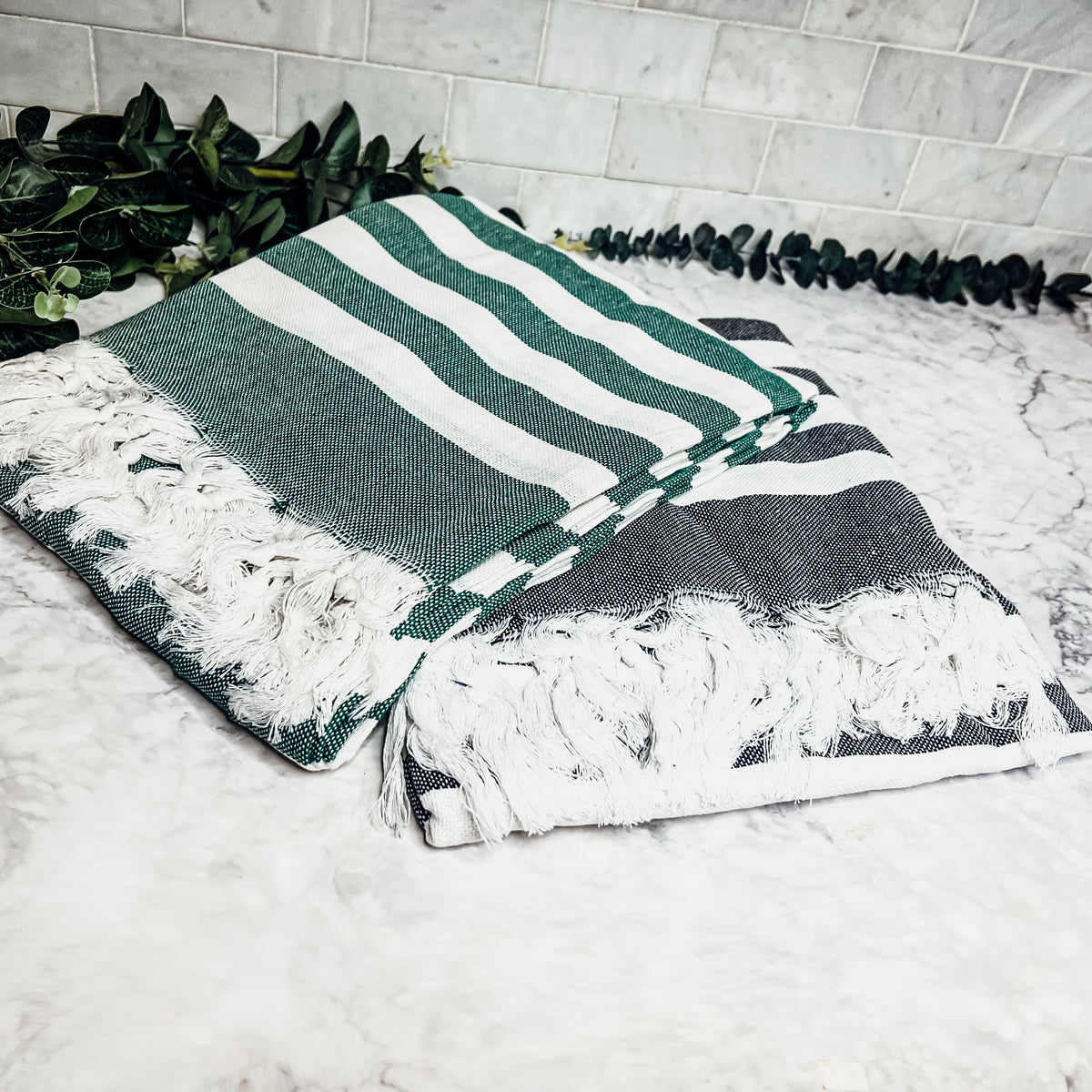 Bold Towel 180GSM made from 100% Turkish cotton, featuring decorative tassels and striped design in charcoal or green.