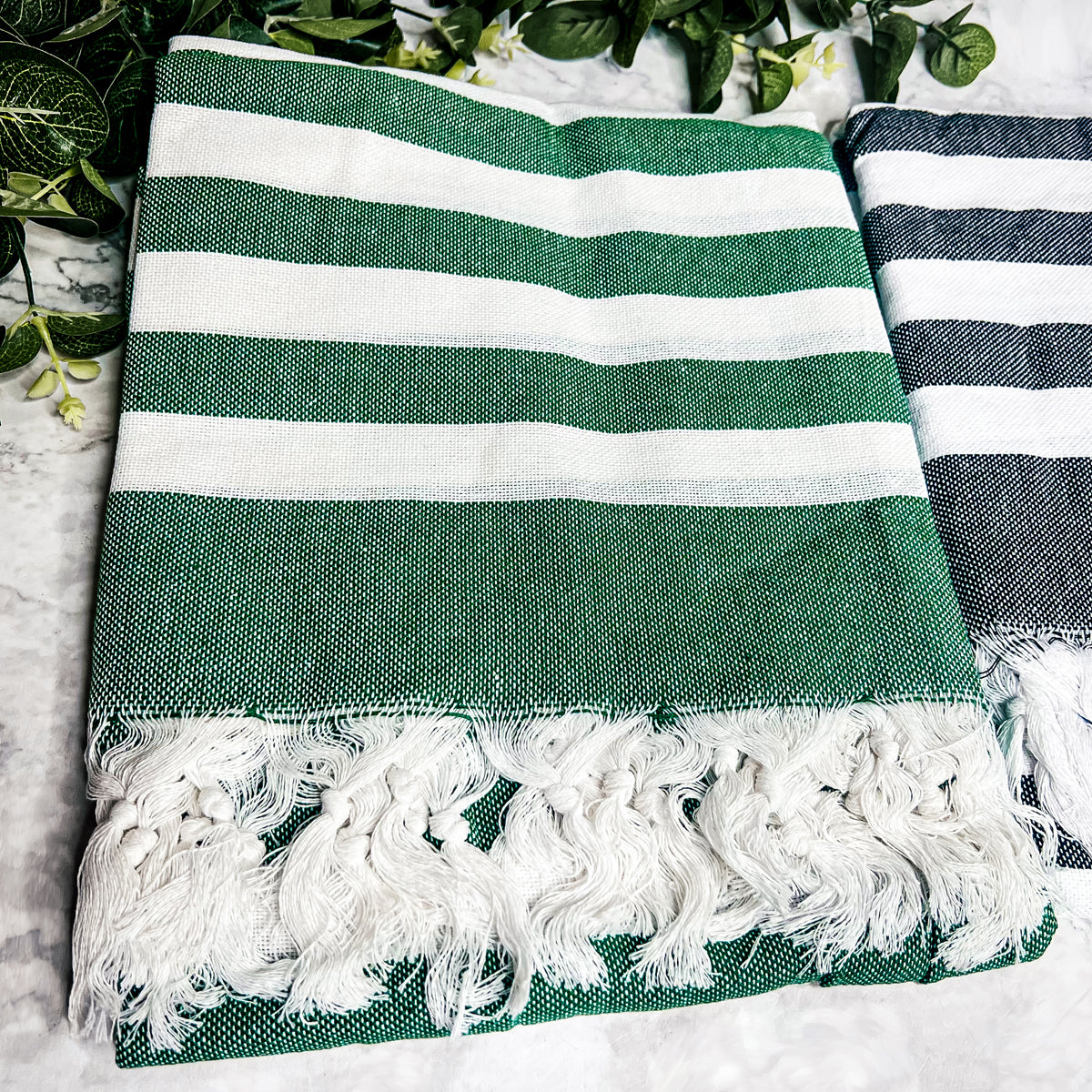 Bold Towel 180GSM made from 100% Turkish cotton, featuring decorative tassels and striped design in charcoal or green.