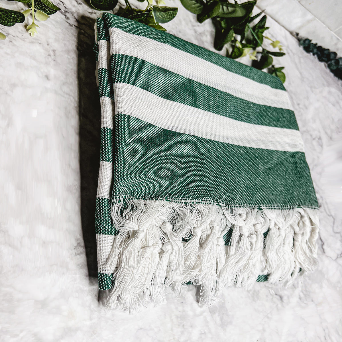 Bold Towel 180GSM made from 100% Turkish cotton, featuring decorative tassels and striped design in charcoal or green.