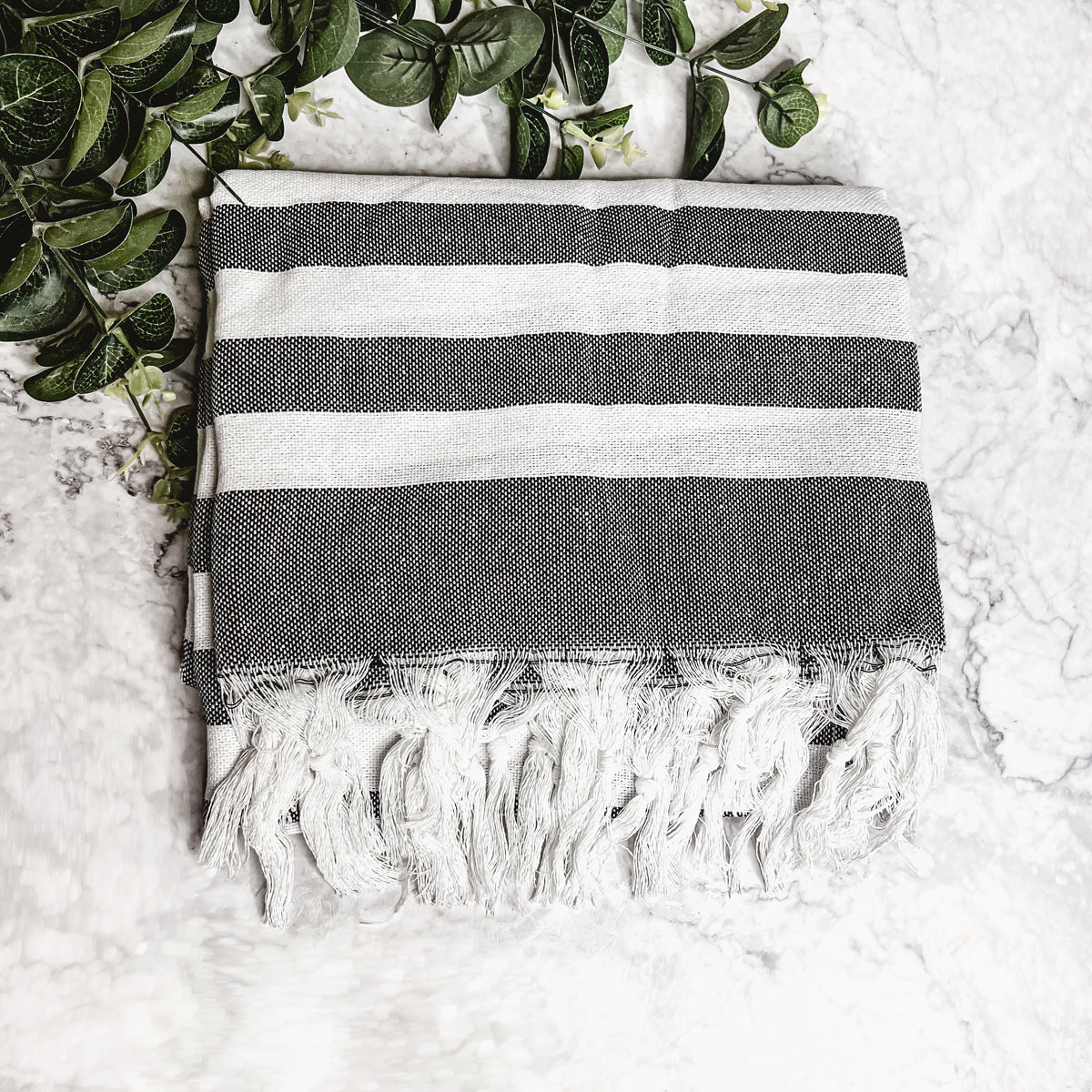 Bold Towel 180GSM made from 100% Turkish cotton, featuring decorative tassels and striped design in charcoal or green.