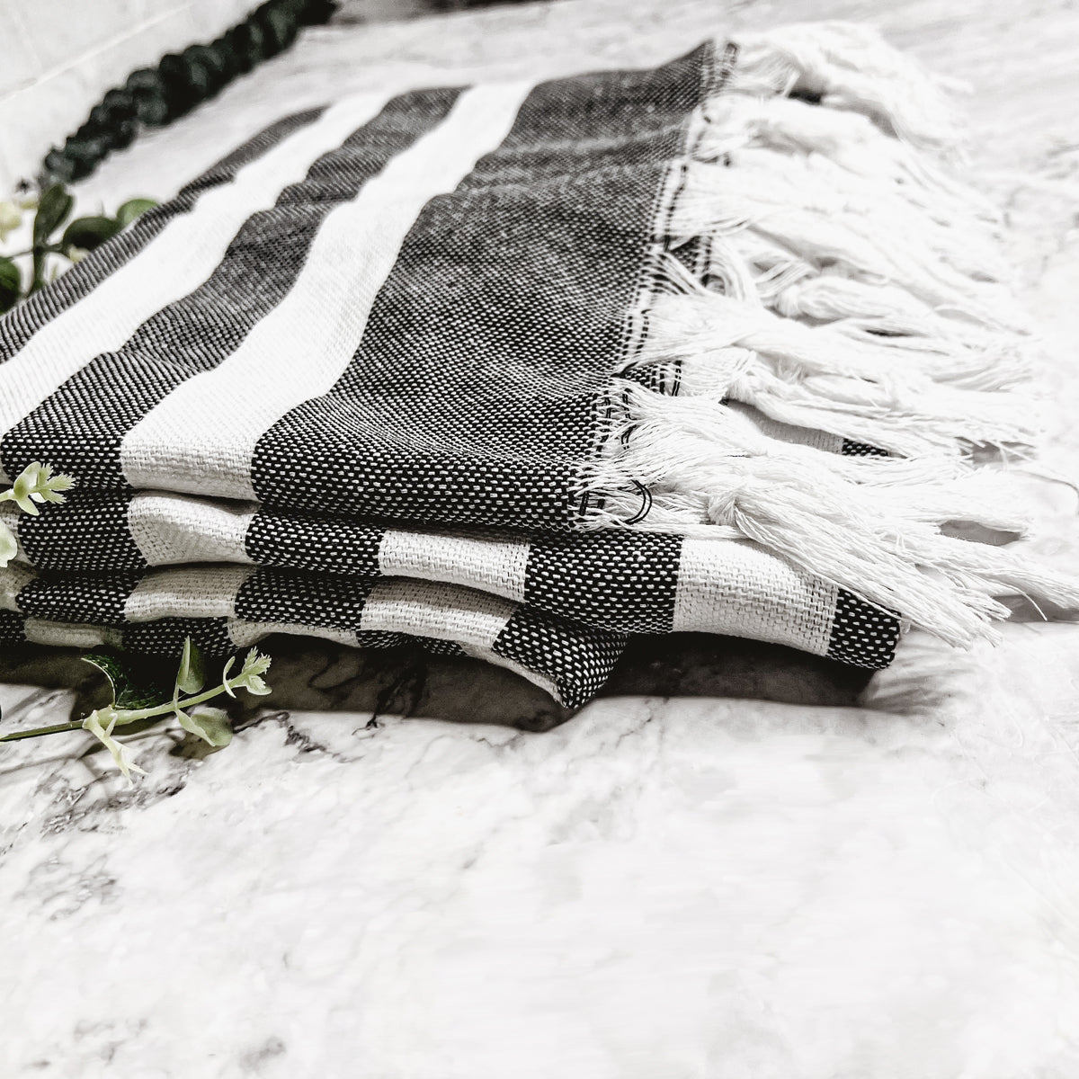 Bold Towel 180GSM made from 100% Turkish cotton, featuring decorative tassels and striped design in charcoal or green.