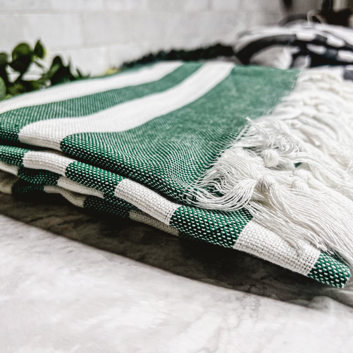 Bold Towel 180GSM made from 100% Turkish cotton, featuring decorative tassels and striped design in charcoal or green.