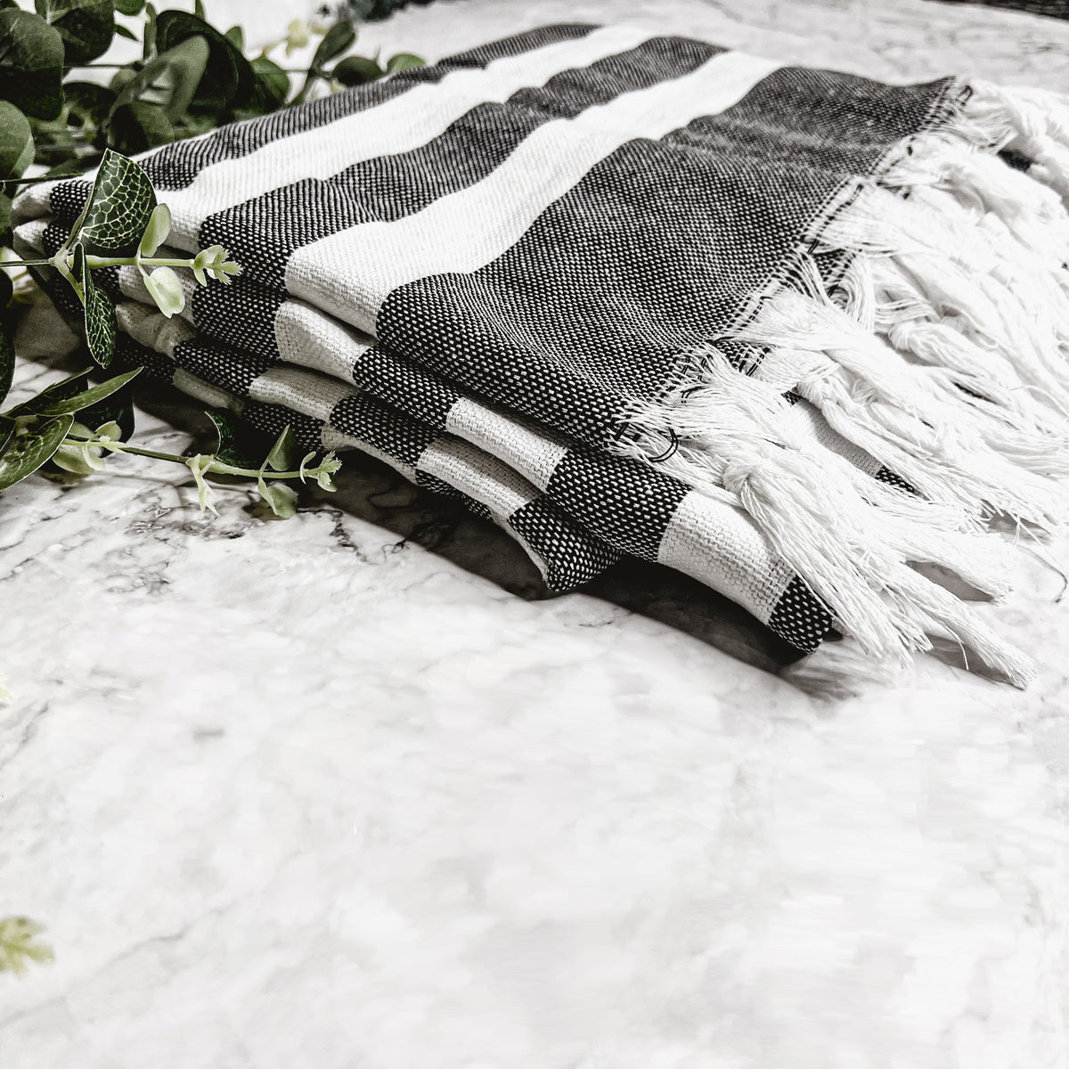 Bold Towel 180GSM made from 100% Turkish cotton, featuring decorative tassels and striped design in charcoal or green.