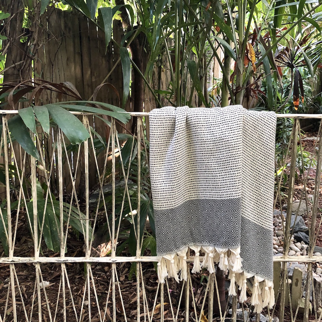 A beautifully crafted Diamond Stripe Turkish Towel showcasing vibrant patterns and tassels, made from 100% Turkish cotton.