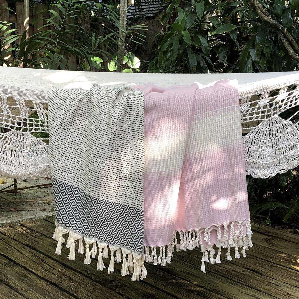 A beautifully crafted Diamond Stripe Turkish Towel showcasing vibrant patterns and tassels, made from 100% Turkish cotton.