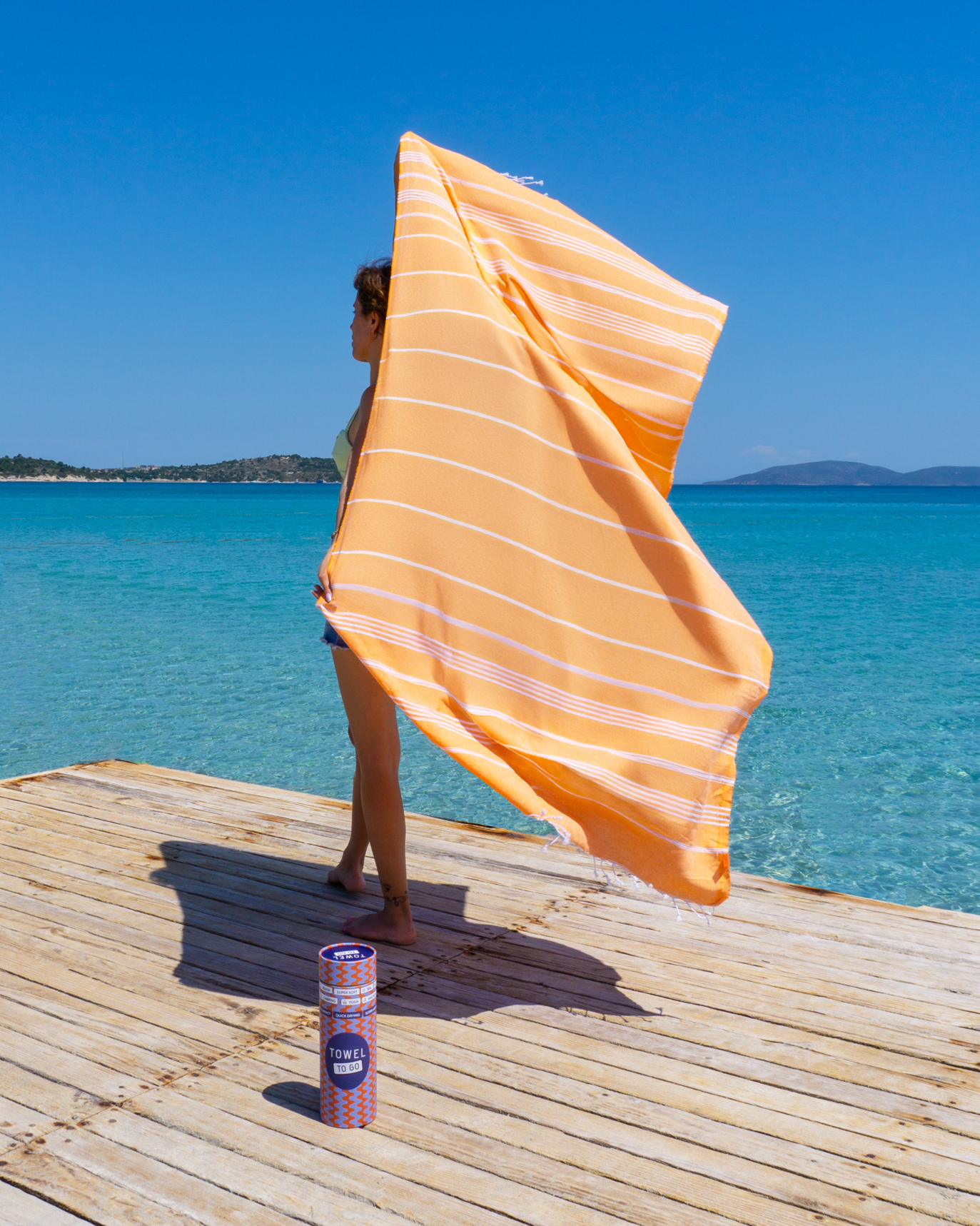 Ipanema Hammam Towel in vibrant orange with white stripes, elegantly displayed in a recycled gift box.