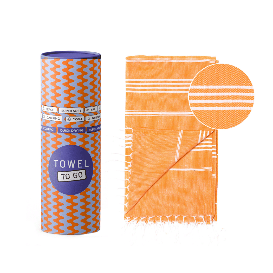 Ipanema Hammam Towel in vibrant orange with white stripes, elegantly displayed in a recycled gift box.