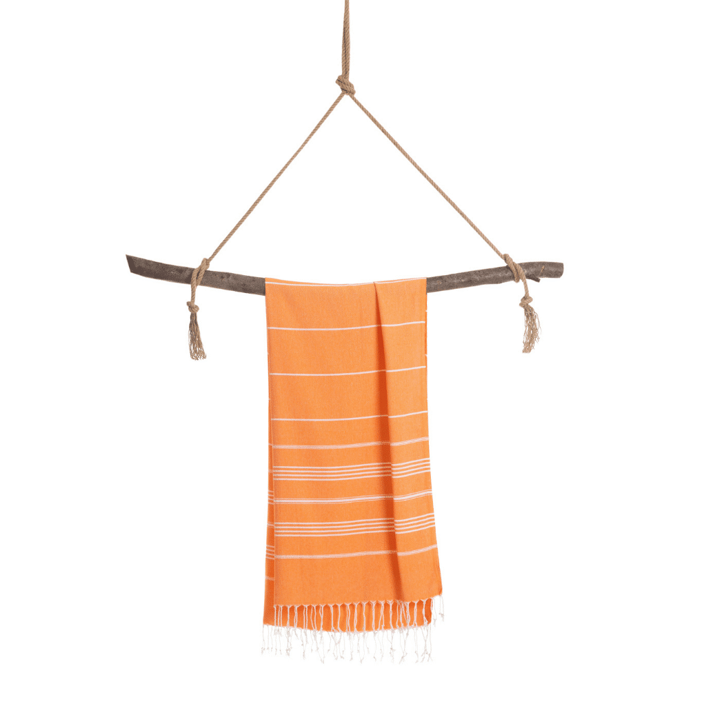 Ipanema Hammam Towel in vibrant orange with white stripes, elegantly displayed in a recycled gift box.