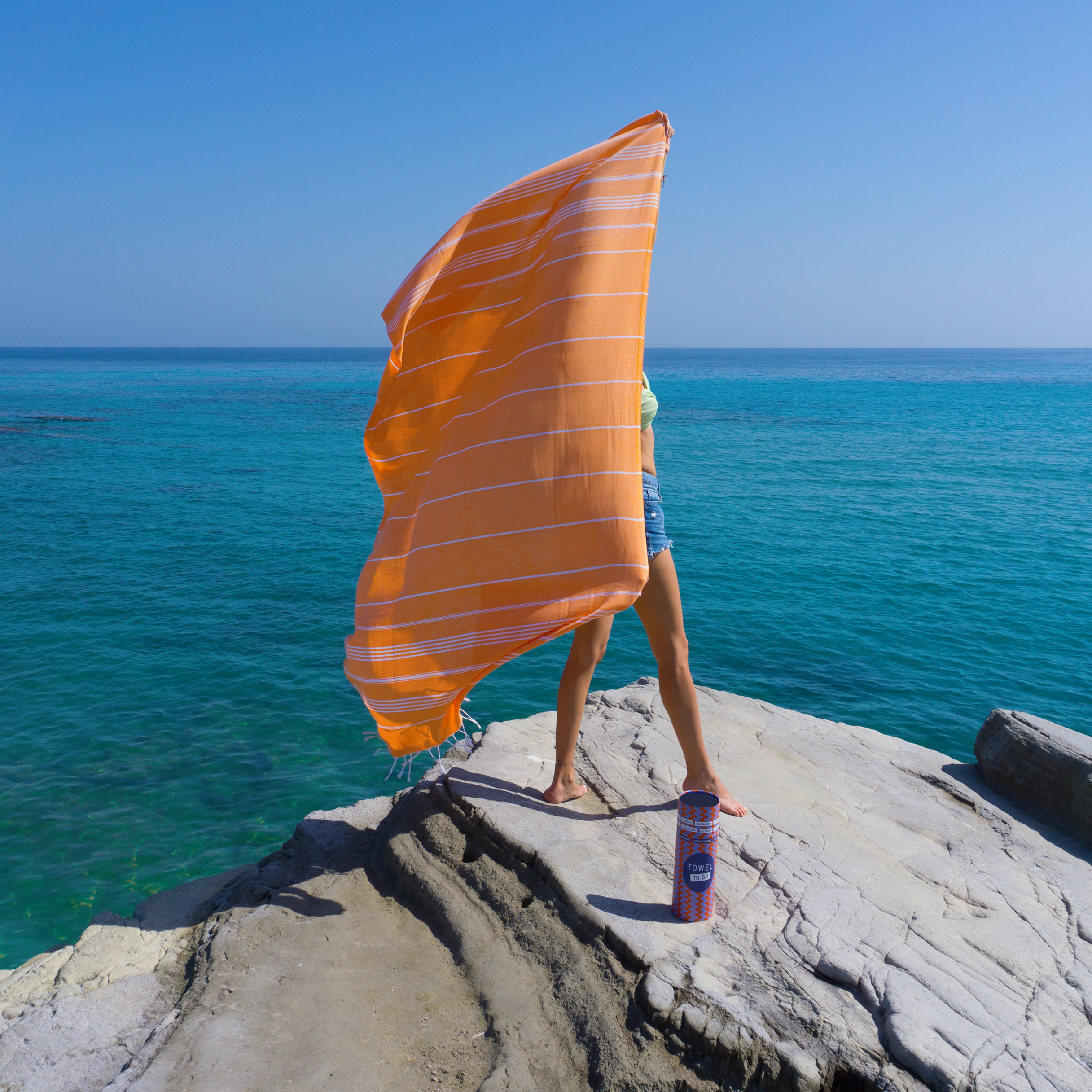 Ipanema Hammam Towel in vibrant orange with white stripes, elegantly displayed in a recycled gift box.